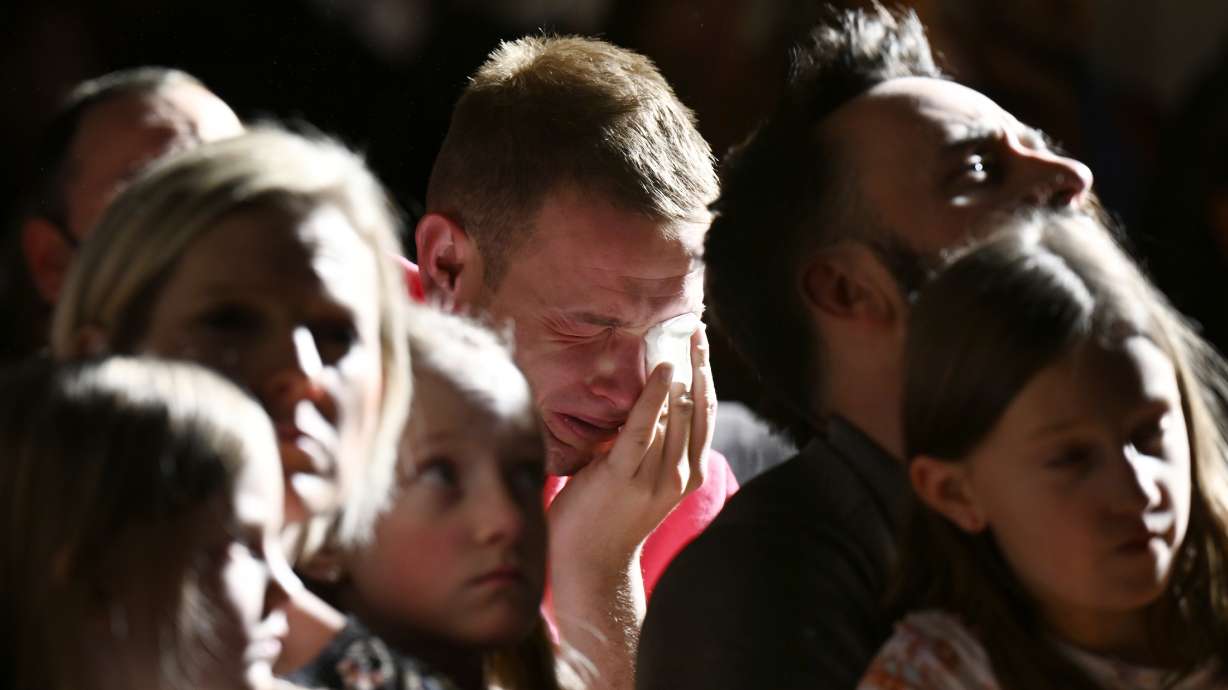R.J. Lewis, center, attends a vigil at All Souls Unitarian Church with others, Sunday in Colorado Springs, Colo., following a fatal shooting at gay nightclub Club Q late the night before.The mayor of Colorado Springs Monday called it "an incredible act of heroism" that patrons of a gay bar managed to subdue the gunman.