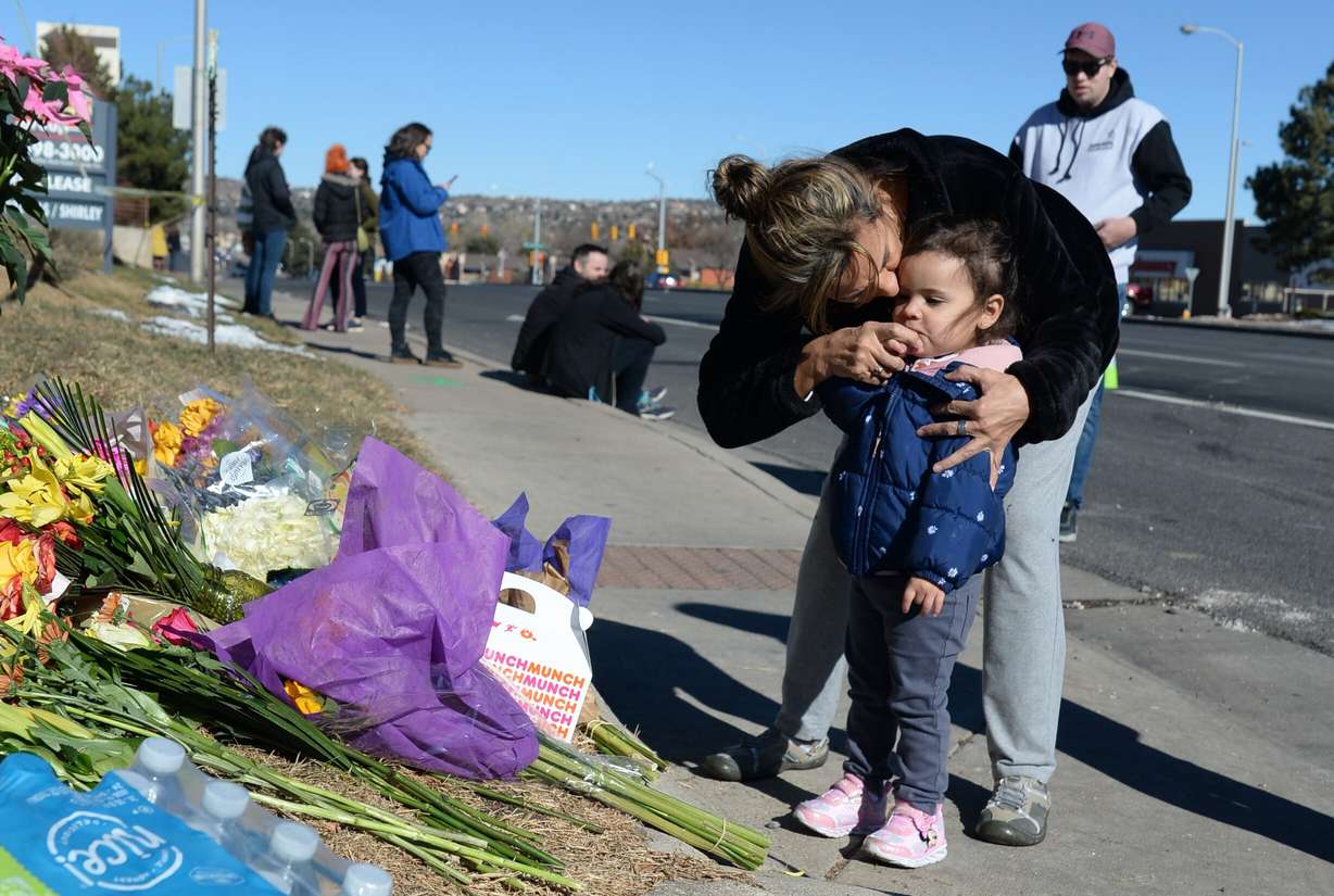 Nelly Brusnell signs a cross on the chest of Ivanna Brusnell after placing flowers near a gay nightclub in Colorado Springs, Colo., Sunday, where a fatal shooting occurred late Saturday night.
