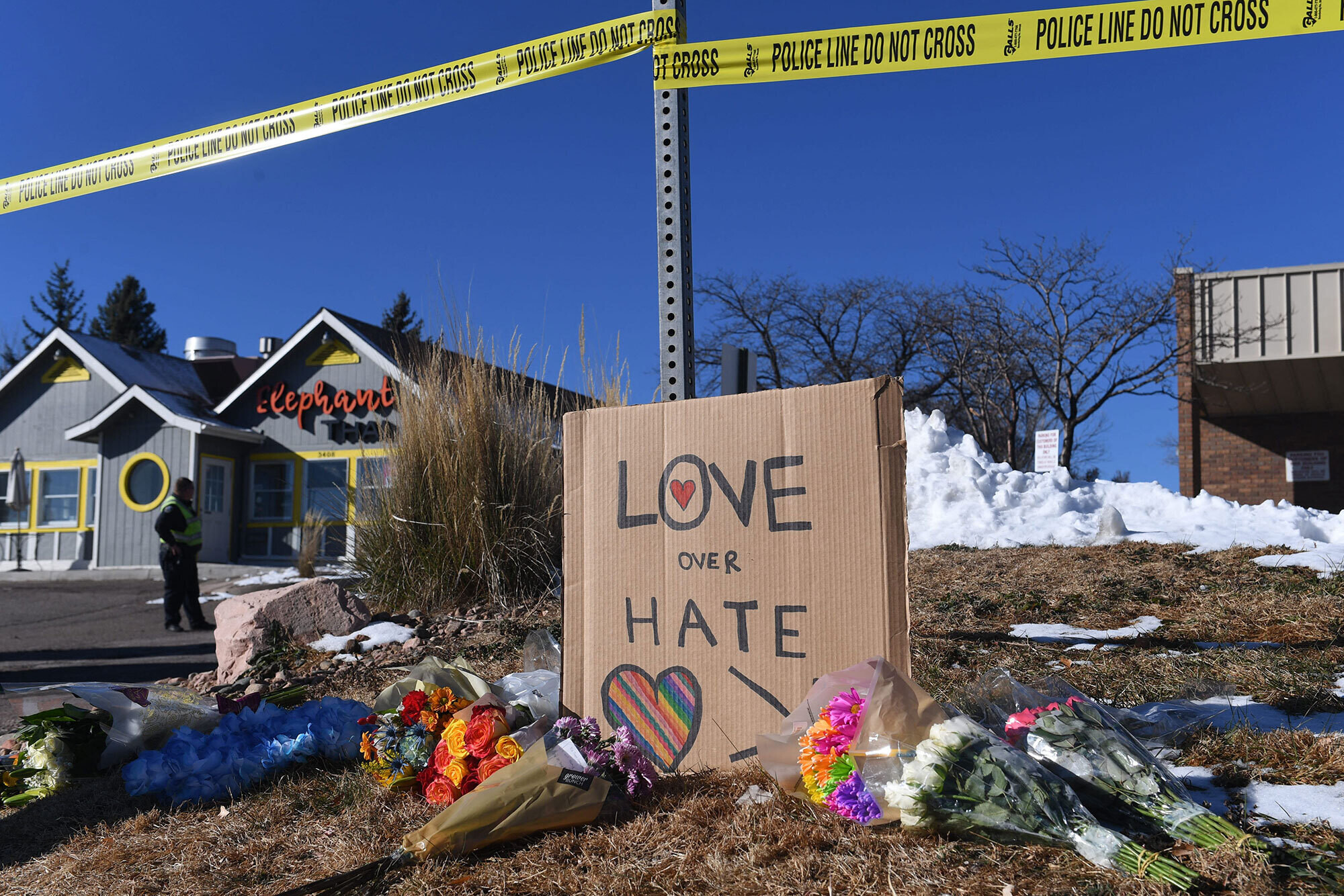 Bouquets of flowers and a sign reading "Love Over Hate" are left near the LGBTQ nightclub where at least 5 people were killed on Sunday, in Colorado Springs, Colo.