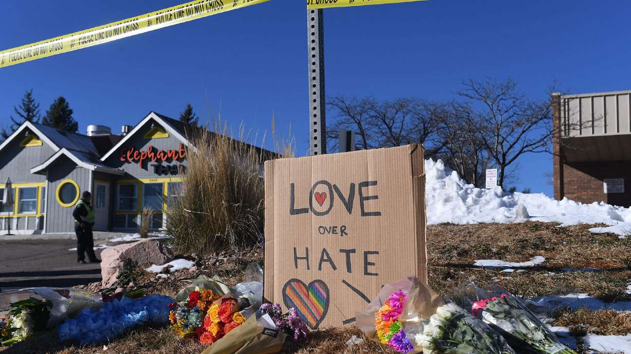 Bouquets of flowers and a sign reading "Love Over Hate" are left near the LGBTQ nightclub where at least 5 people were killed on Sunday, in Colorado Springs, Colo.