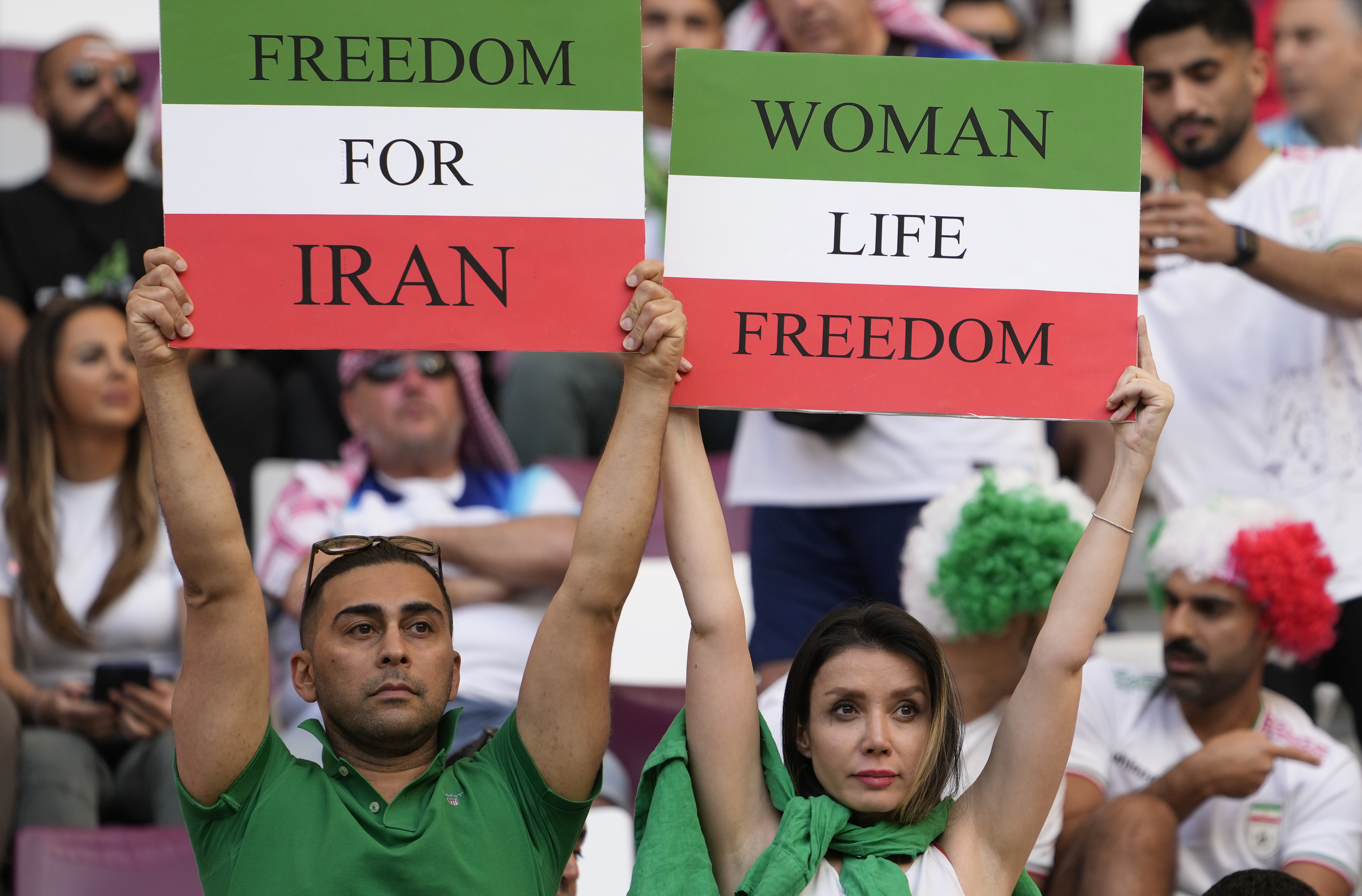 Iranian soccer fans hold up signs reading Woman Life Freedom and Freedom For Iran, prior to the World Cup group B soccer match between England and Iran at the Khalifa International Stadium in in Doha, Qatar, Monday, Nov. 21, 2022. 