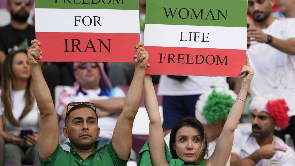 Iranian soccer fans hold up signs reading Woman Life Freedom and Freedom For Iran, prior to the World Cup group B soccer match between England and Iran at the Khalifa International Stadium in in Doha, Qatar, Monday, Nov. 21, 2022.