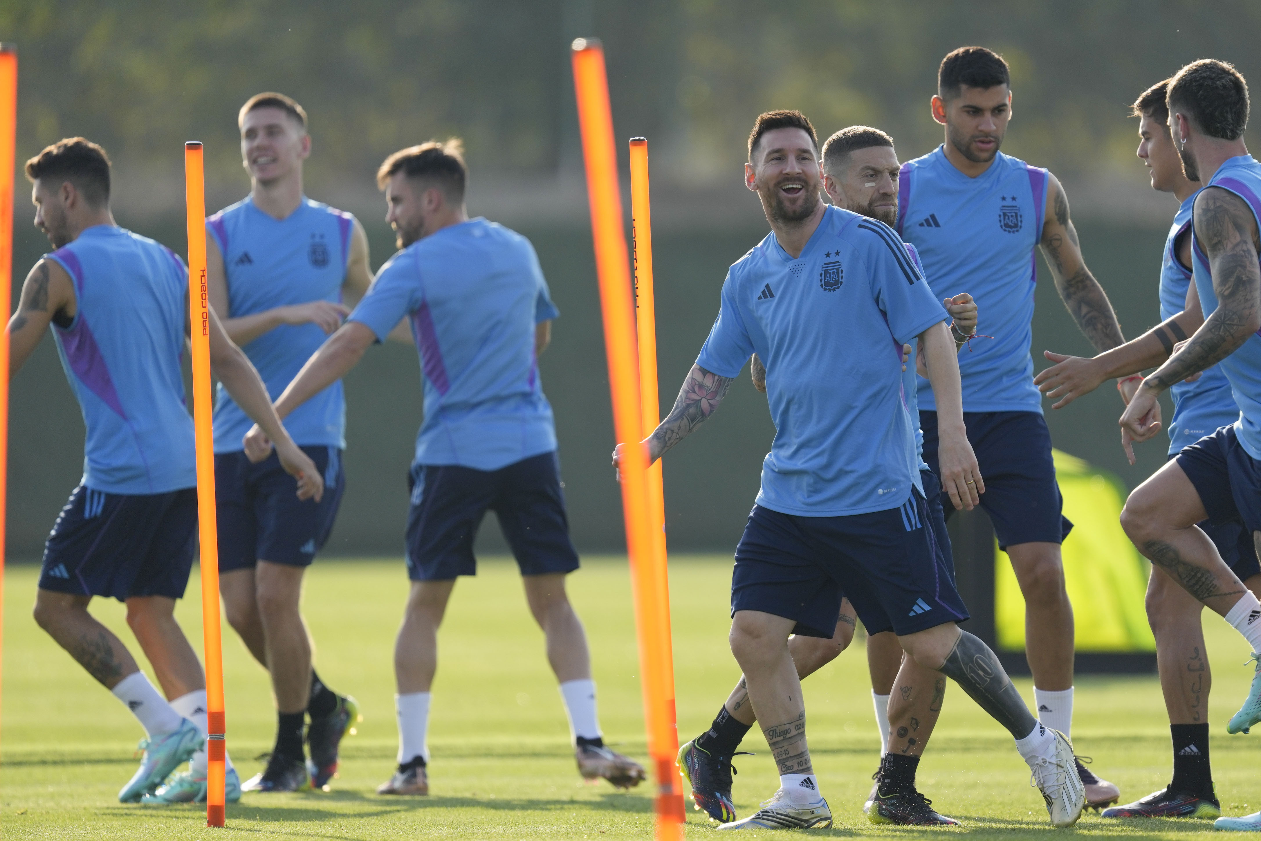 Argentina's Lionel Messi, right, smiles during a training session on the eve of the group C World Cup soccer match against Saudi Arabia, in Doha, Monday, Nov. 21, 2022. 