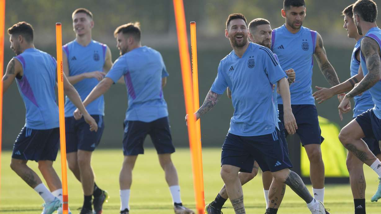 Argentina's Lionel Messi, right, smiles during a training session on the eve of the group C World Cup soccer match against Saudi Arabia, in Doha, Monday, Nov. 21, 2022.