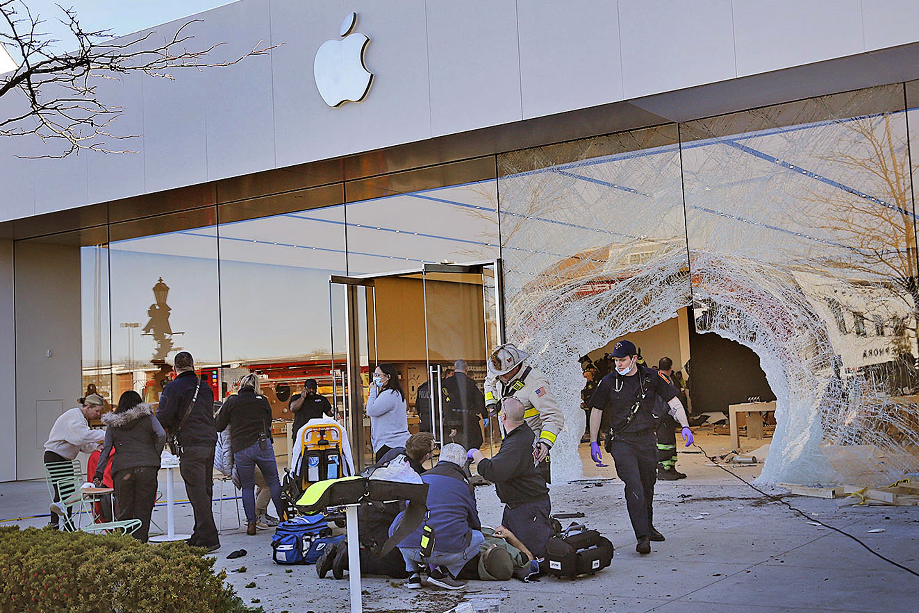 Emergency workers aid injured shoppers after an SUV drove into an Apple store, Monday, in Hingham, Mass. Several people were injured in the incident, according to authorities.