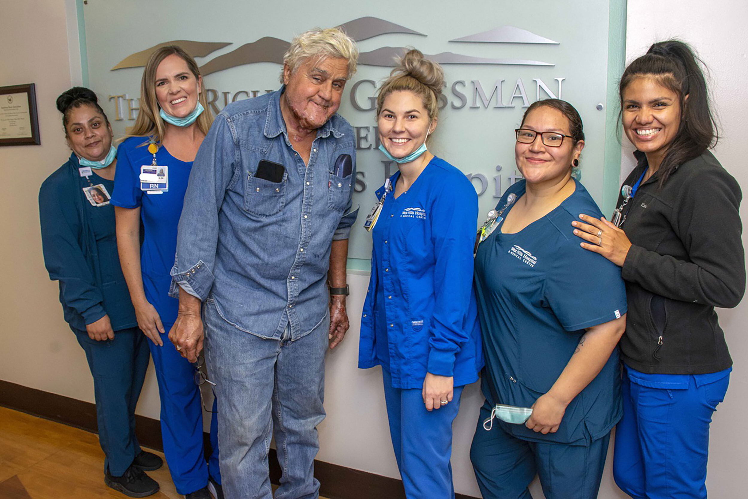 Jay Leno has been discharged from the hospital after sustaining burn injuries in a gasoline fire. Leno is seen here with the staff of the Grossman Burn Center on Monday.