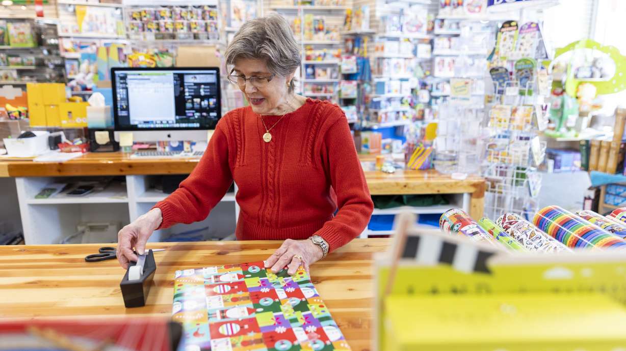 Diane Sartain, co-owner at Tutoring Toy, wraps a present for a customer on Monday in Salt Lake City. The past two years haven't been overly cheery for local businesses struggling through the pandemic and its aftermath, but things appear to be looking up this year amid easing inflation and growing consumer sentiment.