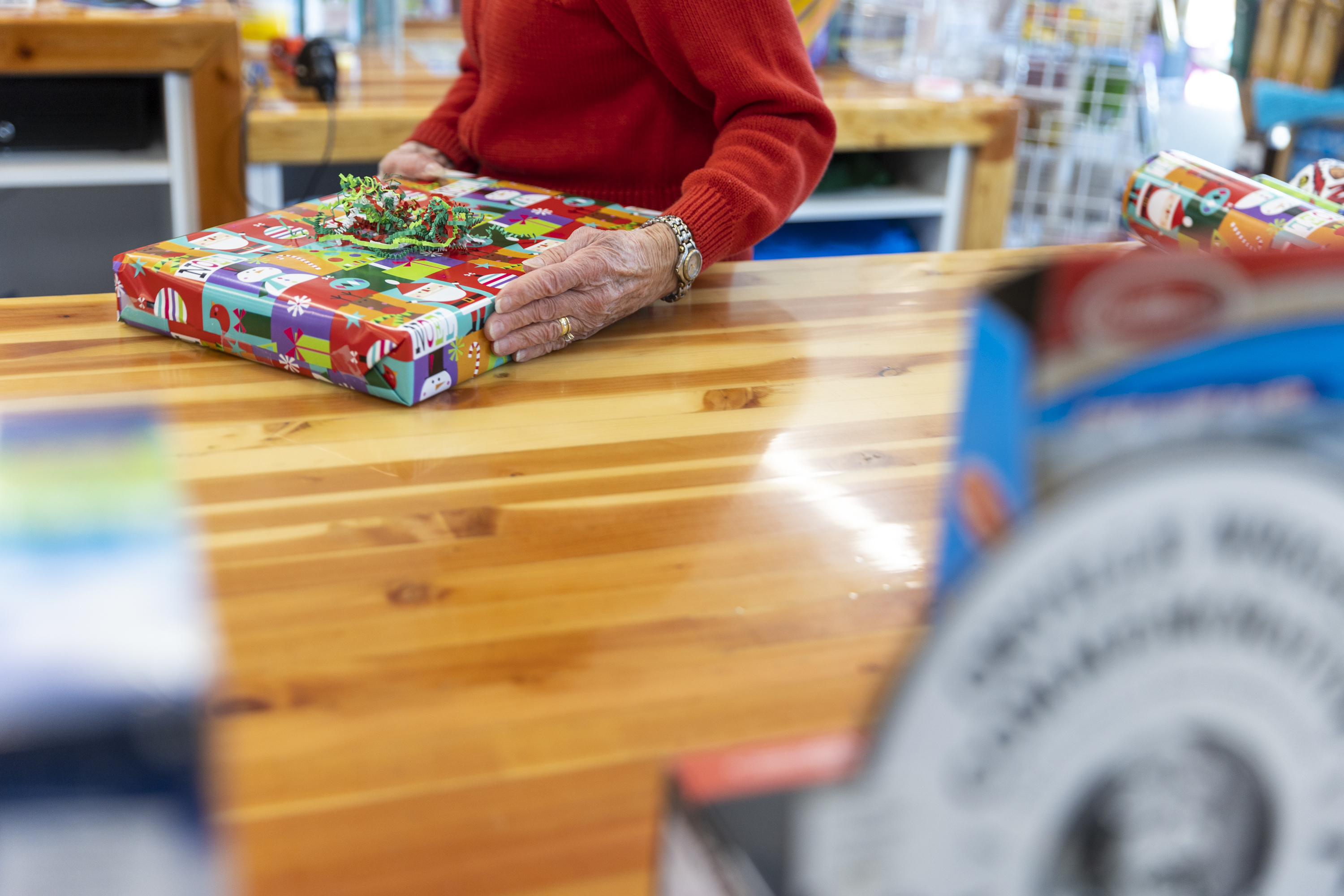 Diane Sartain, co-owner at Tutoring Toy, moves a wrapped present to a customer on Monday in Salt Lake City.