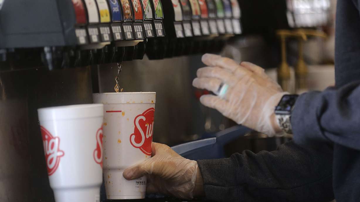 Jennifer Huntington, general manager of Swig in Millcreek, pours a drink for a customer on June 3, 2020. Larry H. Miller Company officials announced Tuesday that they've acquired a majority stake in the business, which has dozens of locations across Utah and four other states.