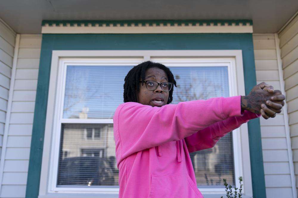 Briana Tyler uses her hands like a gun as she demonstrates the gunman shooting indiscriminately, as she talks about witnessing the mass shooting at a Walmart, Wednesday, in Chesapeake, Va. Tyler said the overnight stocking team of about 15 or 20 people had just gotten together in the break room to go over the morning plan when her manager turned around and opened fire on the staff.