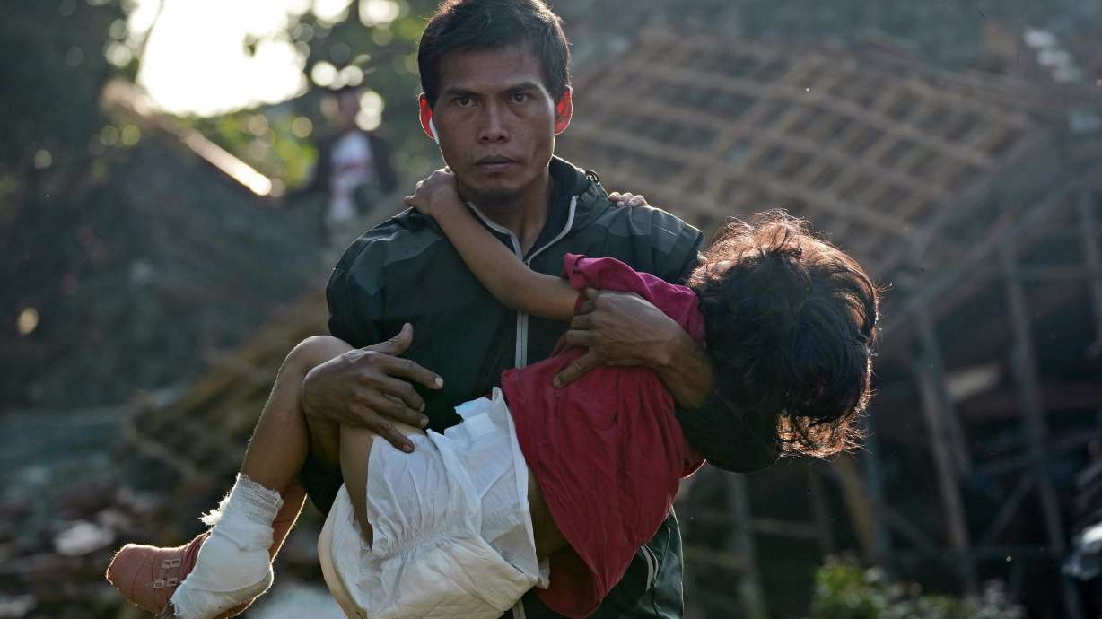 A man carries his injured daughter as they head to a temporary shelter for those displaced by Monday's earthquake in Cianjur, West Java, Indonesia, Thursday. The 5.6 magnitude earthquake left hundreds dead, injured and missing as buildings crumbled and terrified residents ran for their lives on Indonesia's main island of Java.