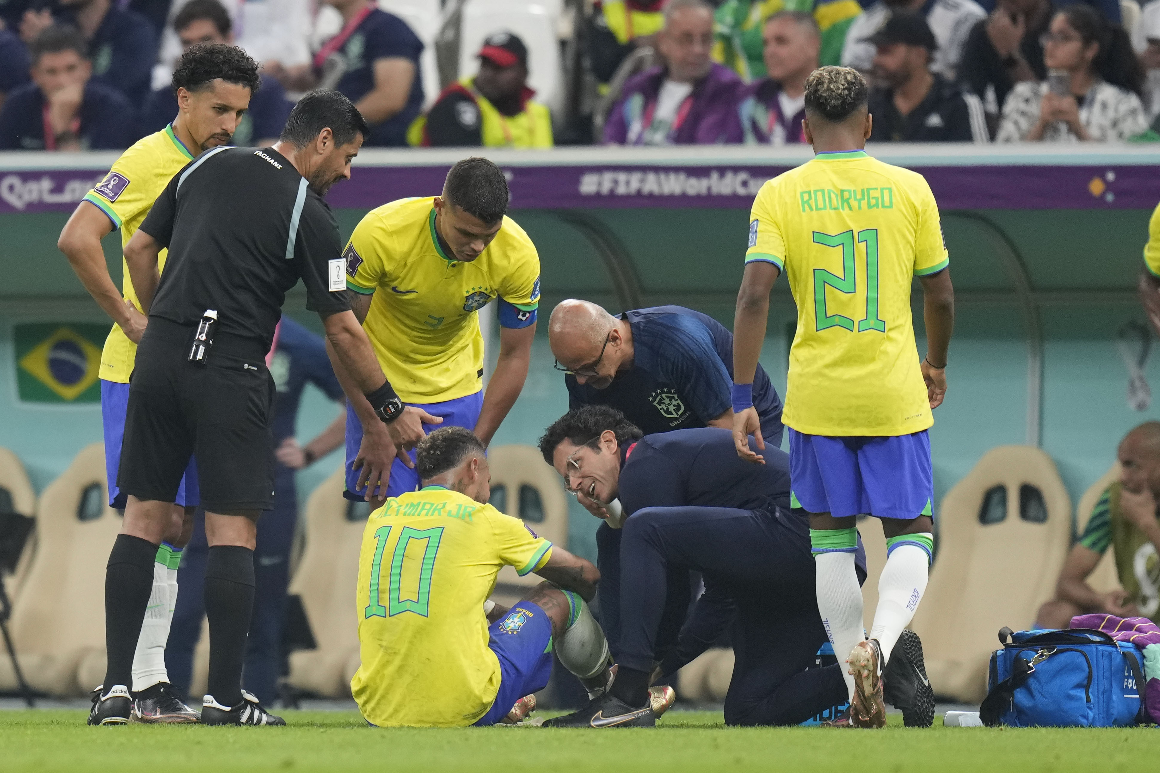 Brazil's Neymar, bottom, is treated by members of his team during the World Cup group G soccer match between Brazil and Serbia, at the Lusail Stadium in Lusail, Qatar, Thursday, Nov. 24, 2022. 