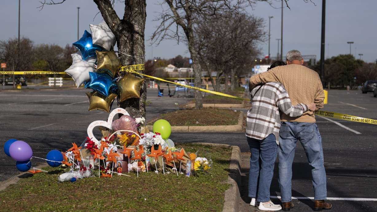 Debbie, left, and Chet Barnett place flowers at a memorial outside of the Chesapeake, Va., Walmart on Thursday. Andre Bing, a Walmart manager, opened fire on fellow employees in the break room of the Virginia store, killing six people in the country’s second high-profile mass shooting in four days, police and witnesses said Wednesday.