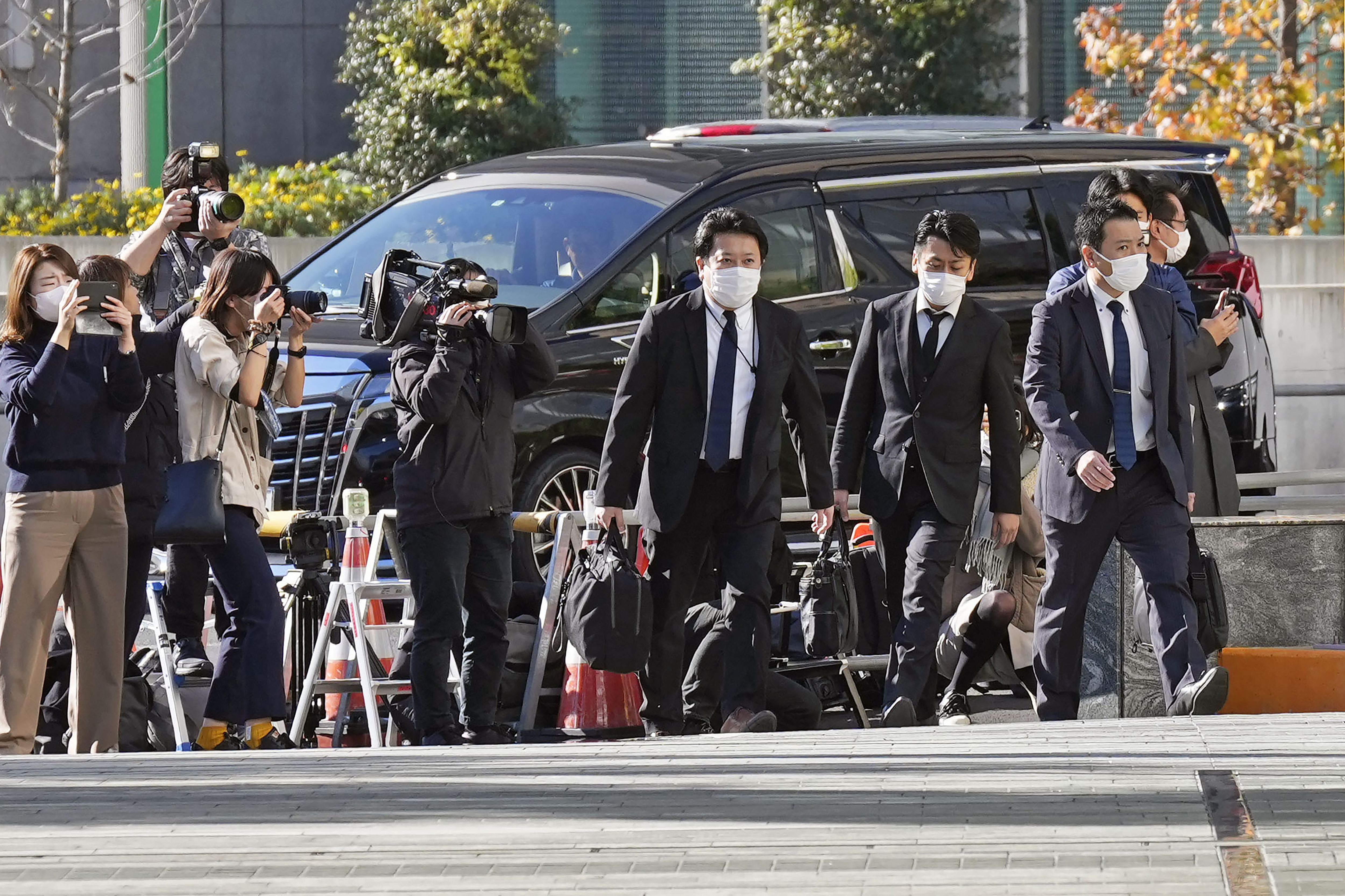 Investigators enter the headquarters of major advertising company Dentsu in Tokyo Friday, Nov. 25, 2022. Japanese prosecutors raided the headquarters of Dentsu Friday, as the investigation into corruption related to the Tokyo Olympics widened. 