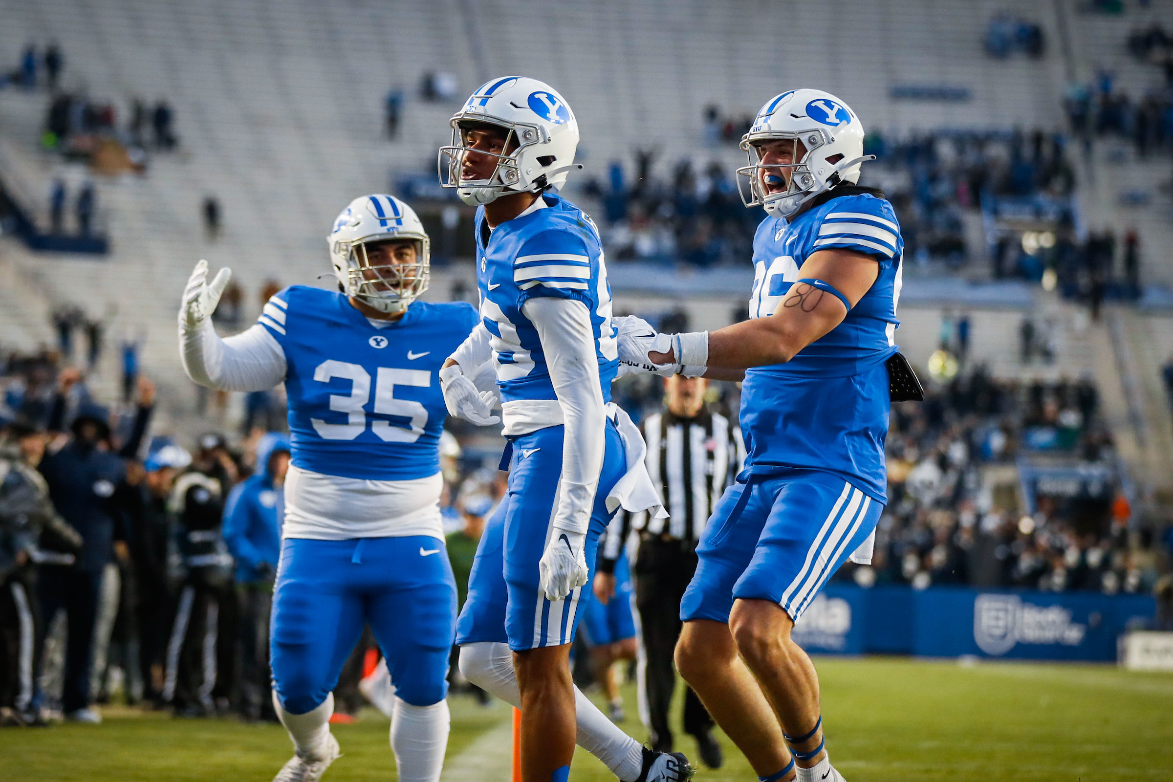 BYU receiver Terence Fall is congratulated by teammates Carter Wheat, right, and Houston Heimuli after scoring a touchdown against Utah Tech, Saturday, Dec. 19, 2022 at LaVell Edwards Stadium in Provo.