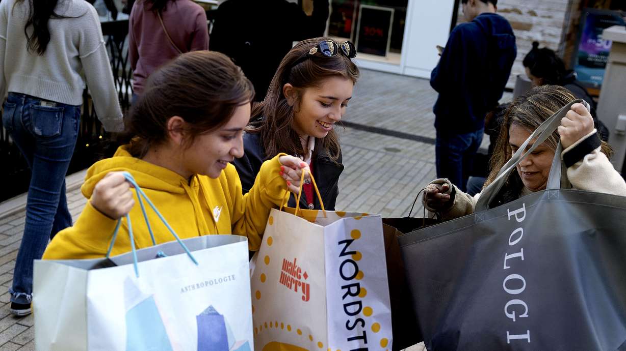 Stela Martinez, left, her sister Isabel and mother Sandra, organize their purchases at City Creek Center in Salt Lake City on Friday. The sisters are students at BYU and their mother was visiting from Orange, California.