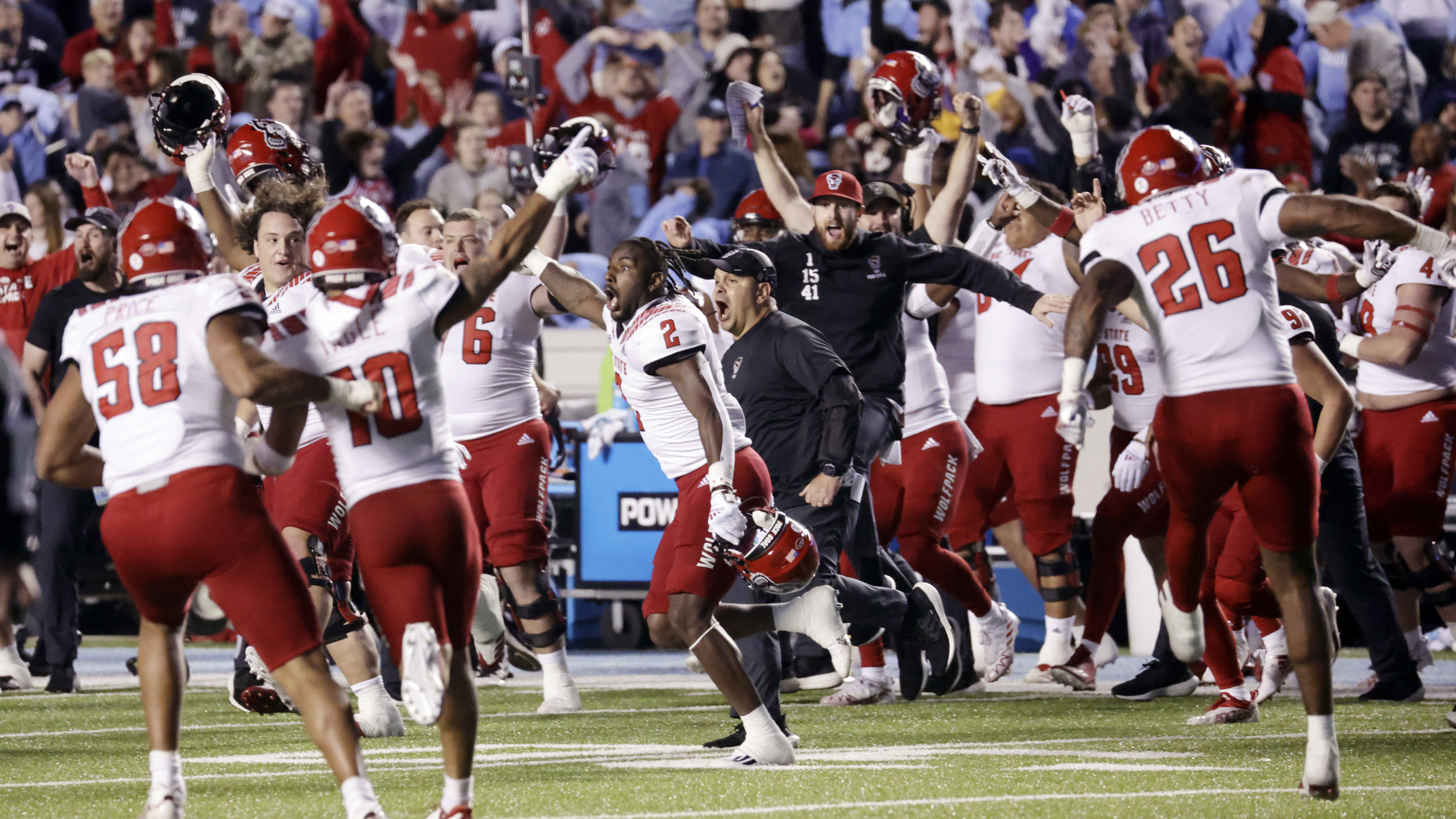 North Carolina State players and coaches celebrate after North Carolina missed a field-goal attempt in the second overtime, giving North Carolina State a 30-27 win in an NCAA college football game Friday, Nov. 25, 2022, in Chapel Hill, N.C. 