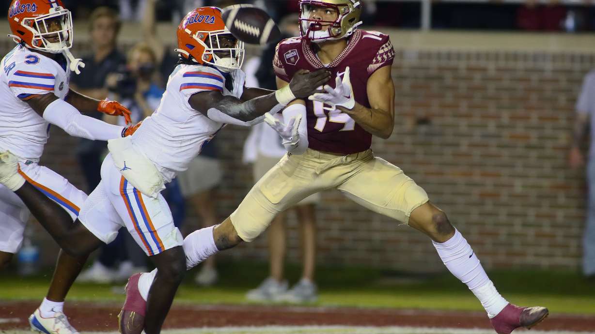 Florida State wide receiver Johnny Wilson (14) is unable to hold onto a pass in the end zone as Florida safety Kamari Wilson (5) defends in the first quarter of an NCAA college football game, Friday, Nov. 25, 2022, in Tallahassee, Fla.