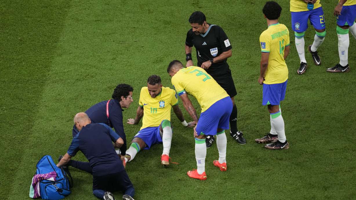 Brazil's Neymar, lies on the pitch as he receives first aid during the World Cup group G soccer match between Brazil and Serbia, at the the Lusail Stadium in Lusail, Qatar on Thursday, Nov. 24, 2022.