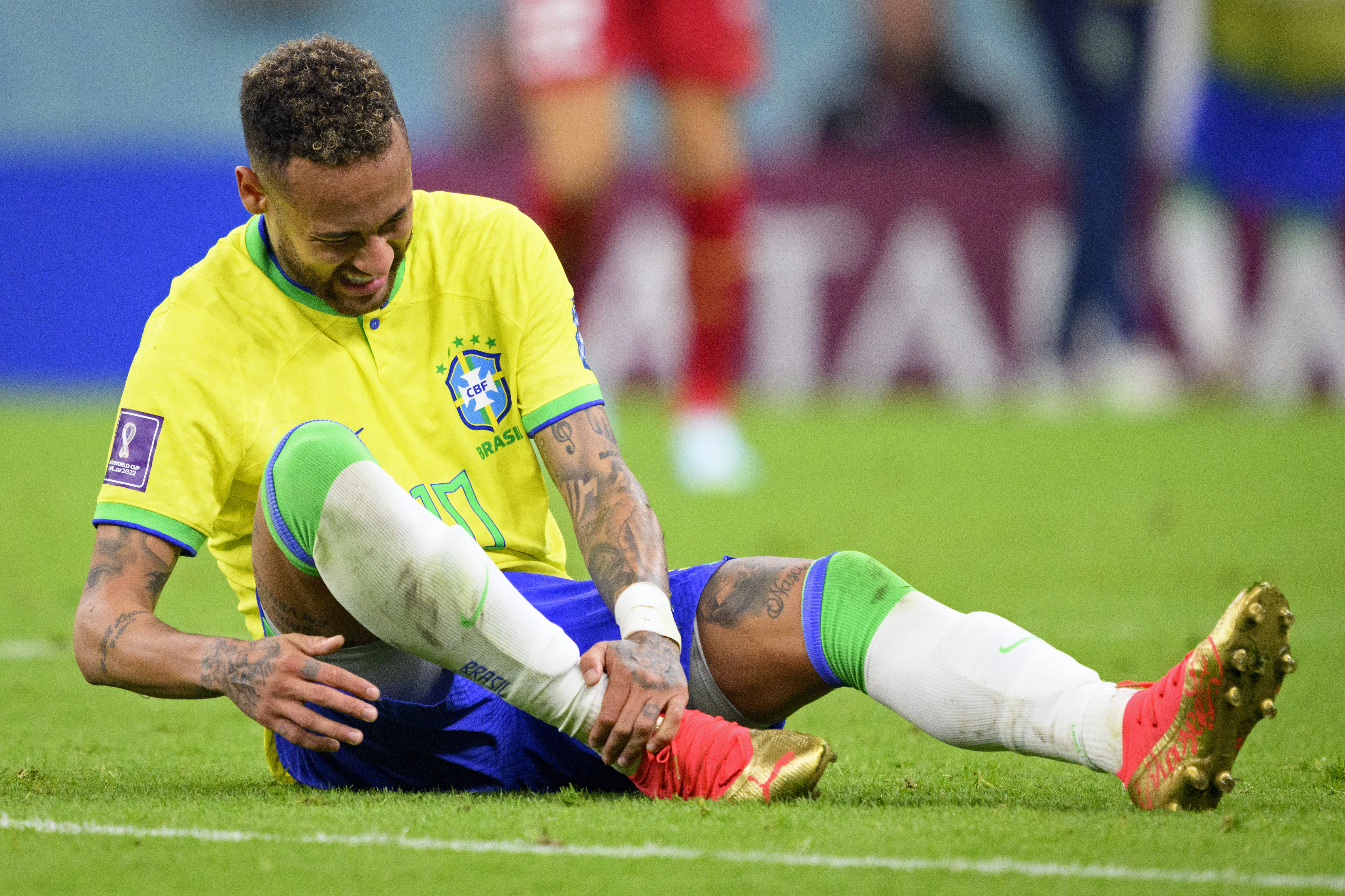 Brazil's Neymar grabs his ankle after an injury during the World Cup group G soccer match between Brazil and Serbia, at the the Lusail Stadium in Lusail, Qatar on Thursday, Nov. 24, 2022.