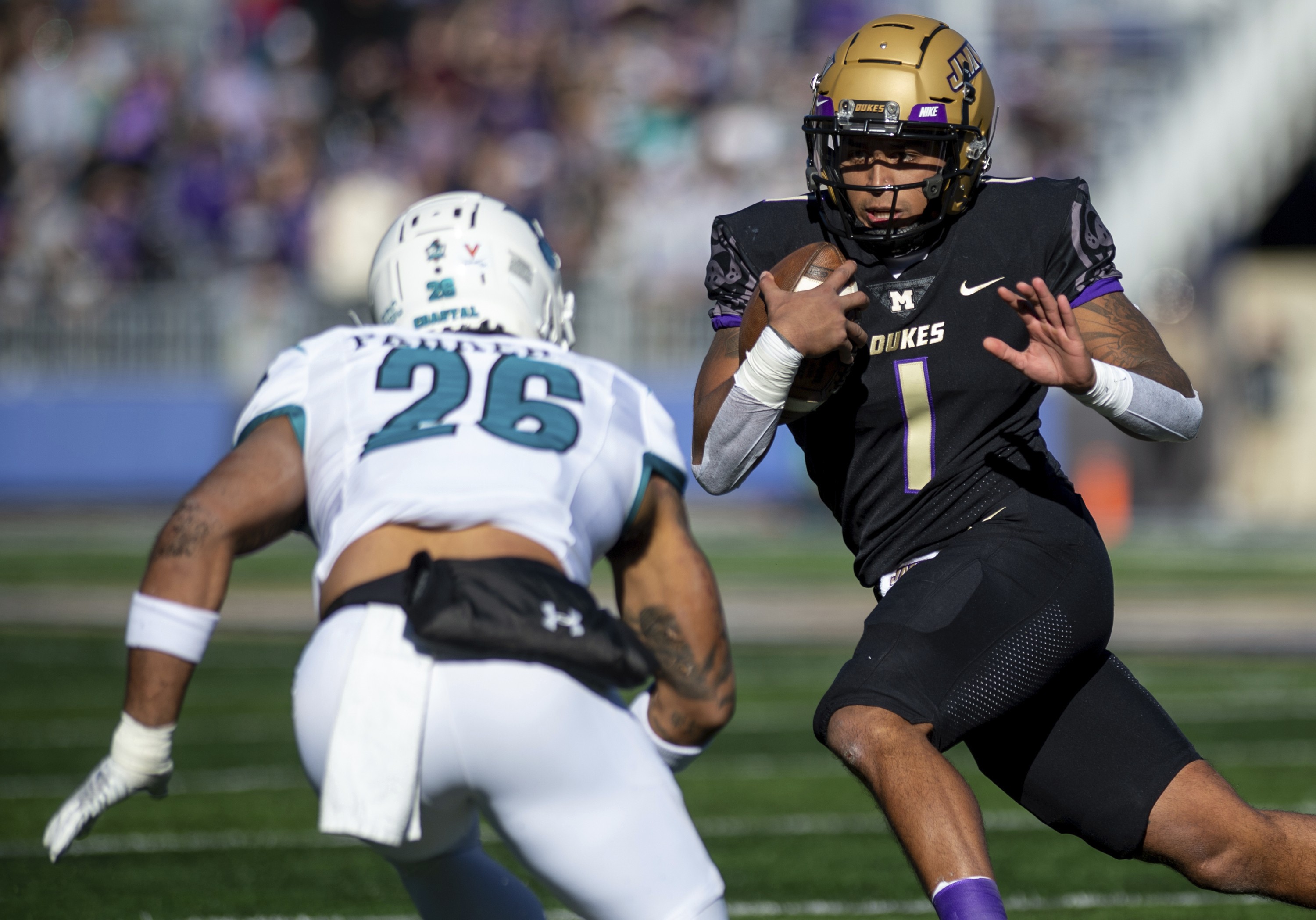 James Madison quarterback Todd Centeio (1) stares down Coastal Carolina safety Jairan Parker (26) during the first half of an NCAA college football game in Harrisonburg, Va., Saturday, Nov. 26, 2022. 