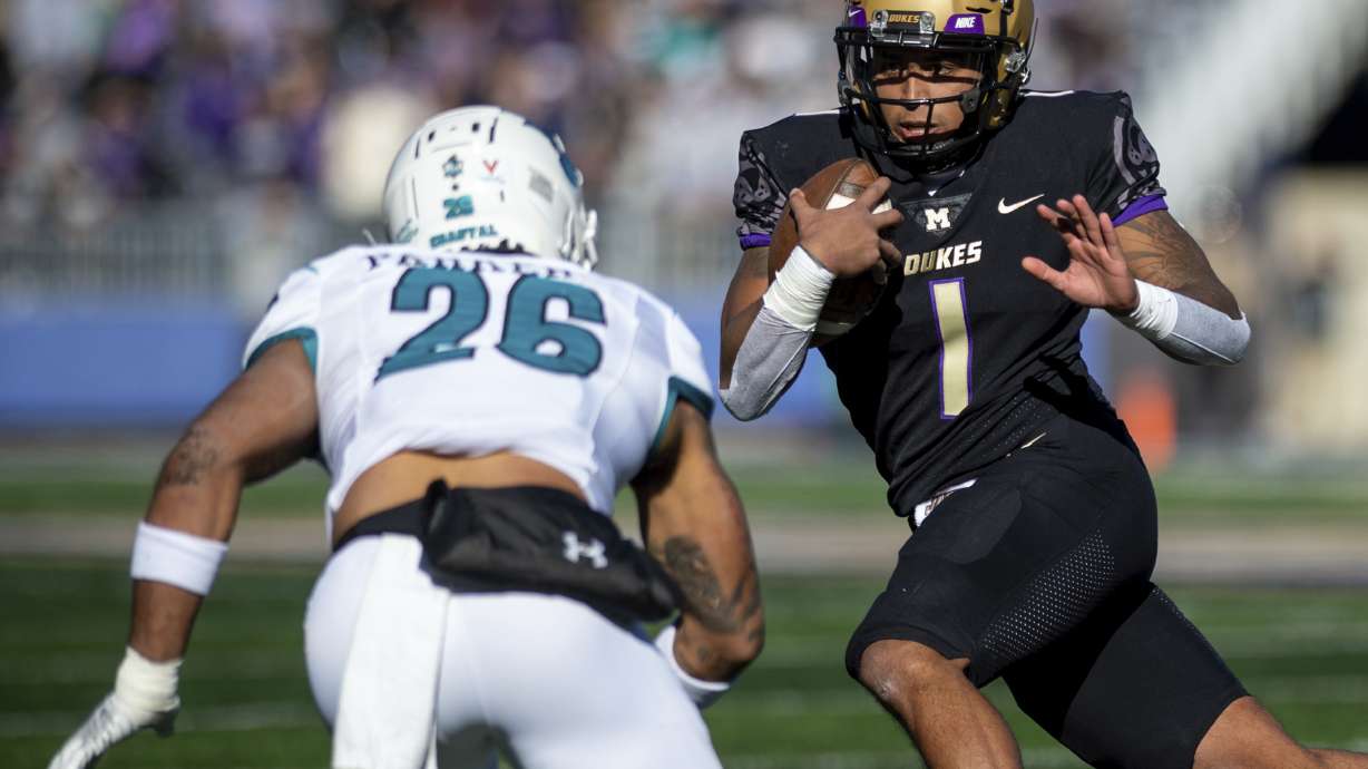 James Madison quarterback Todd Centeio (1) stares down Coastal Carolina safety Jairan Parker (26) during the first half of an NCAA college football game in Harrisonburg, Va., Saturday, Nov. 26, 2022.