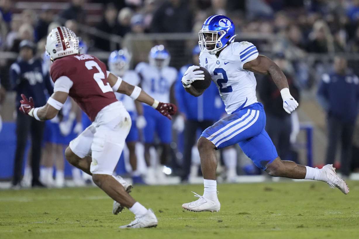 BYU running back Christopher Brooks, right, runs the ball against Stanford during the first half of an NCAA college football game in Stanford, Calif., Saturday, Nov. 26, 2022.