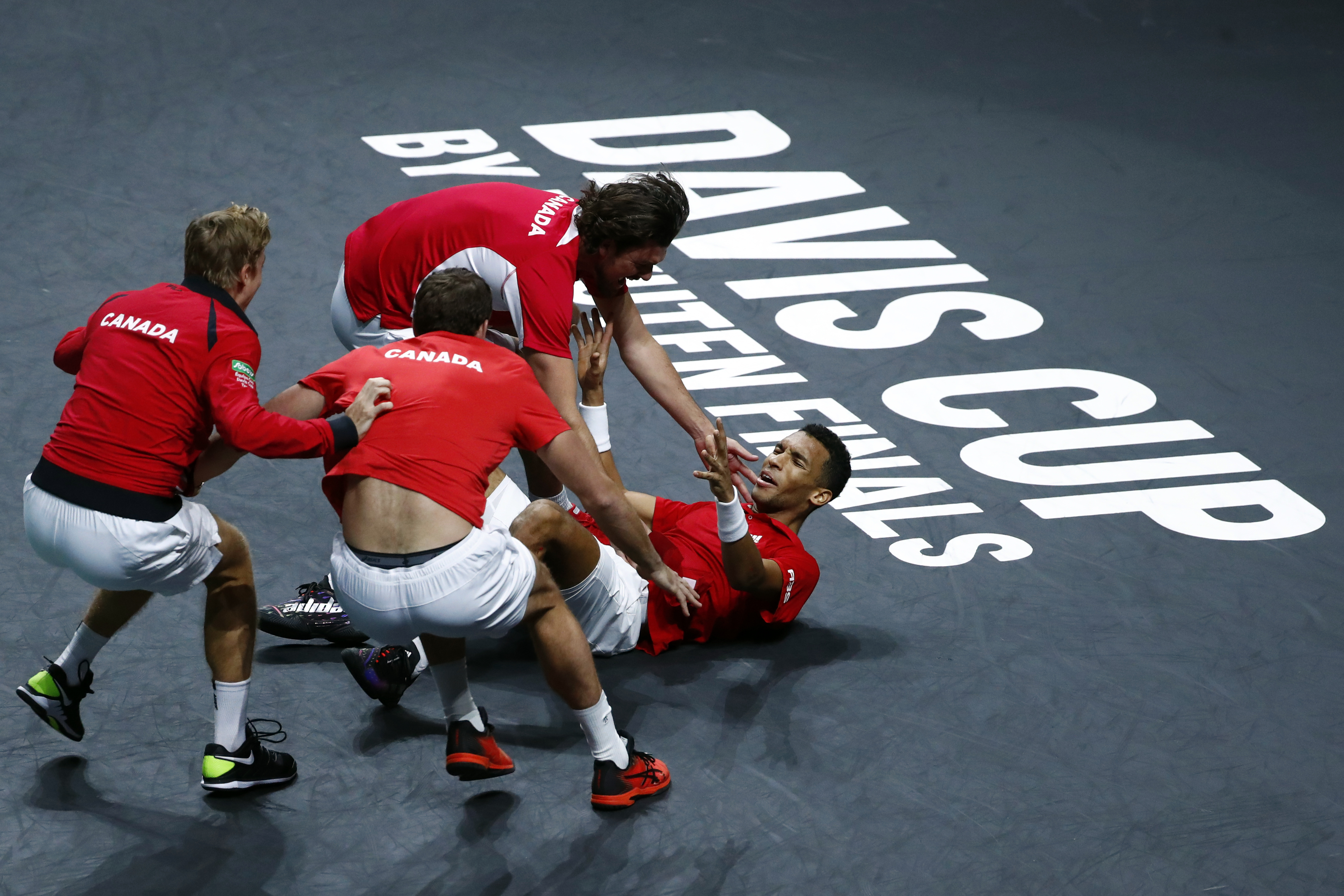 Canada's Felix Auger Aliassime, right, celebrates with teammate after defeating Australia's Alex de Minaur during the final Davis Cup tennis match between Australia and Canada in Malaga, Spain, Sunday, Nov. 27, 2022.