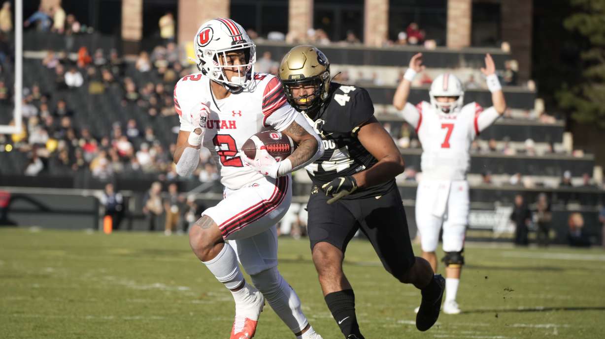 Utah running back Micah Bernard (2) runs past Colorado linebacker Devin Grant (44) for a touchdown as Utah quarterback Cameron Rising (7) gestures in the first half of an NCAA college football game Saturday, Nov. 26, 2022, in Boulder, Colo.
