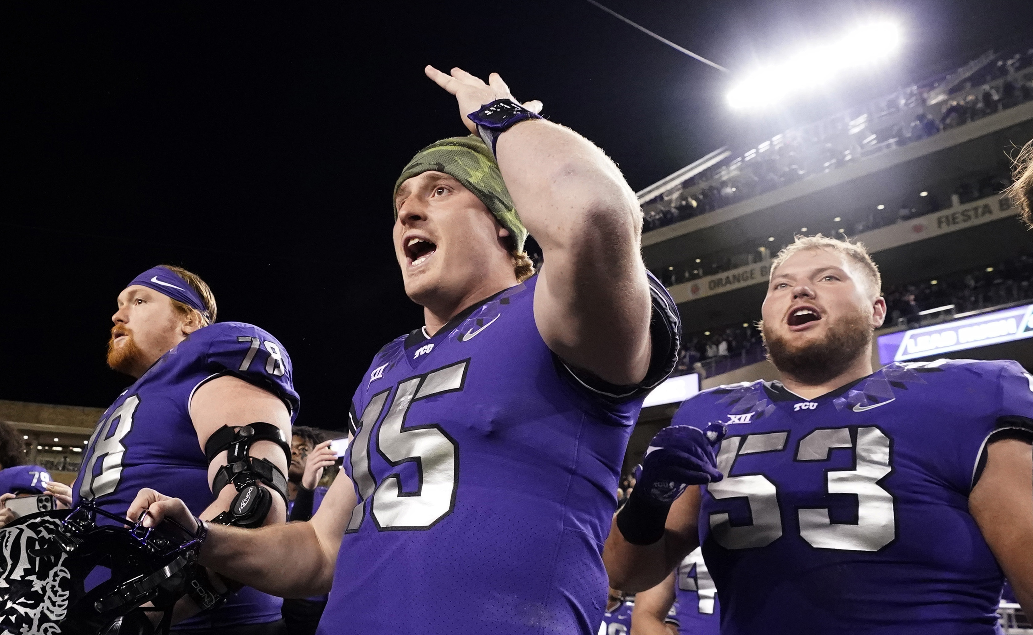 TCU quarterback Max Duggan (15) reacts on the sidelines with teammates guards John Lanz (53) and Wes Harris during the second half of an NCAA college football game against Iowa State in Fort Worth, Texas, Saturday, Nov. 26, 2022. TCU won 62-14. 
