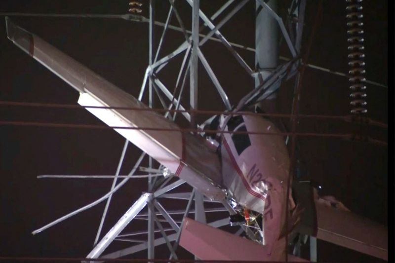 A small airplane hangs about 100 feet above the ground after crashing into an electricity tower in Gaithersburg, Maryland, Sunday, in a still image from video. 