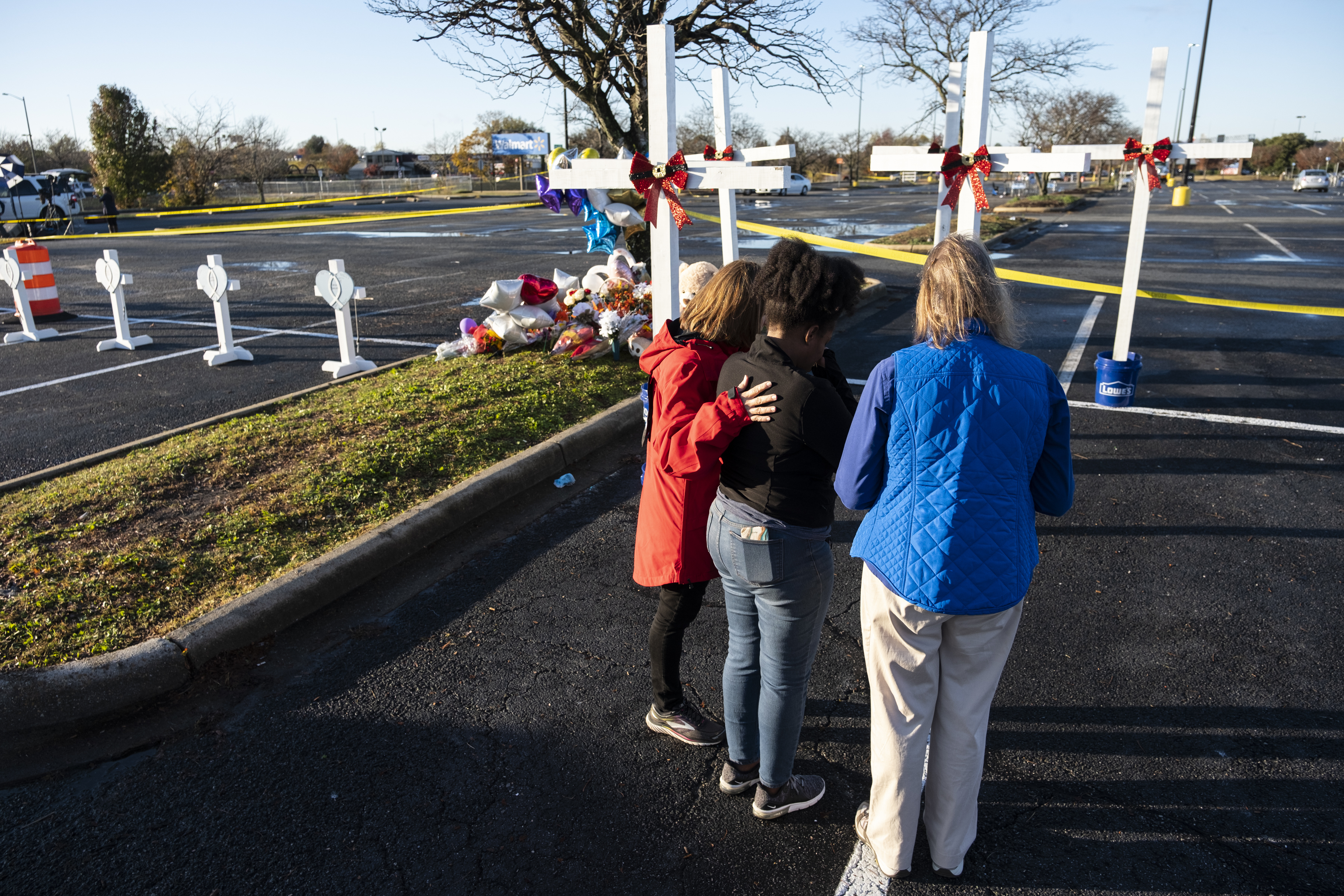 Sheree Perry of Virginia Beach, center, prays with chaplains at a memorial on Friday, for the six killed in a Chesapeake, Va., Walmart mass shooting earlier in the week.
