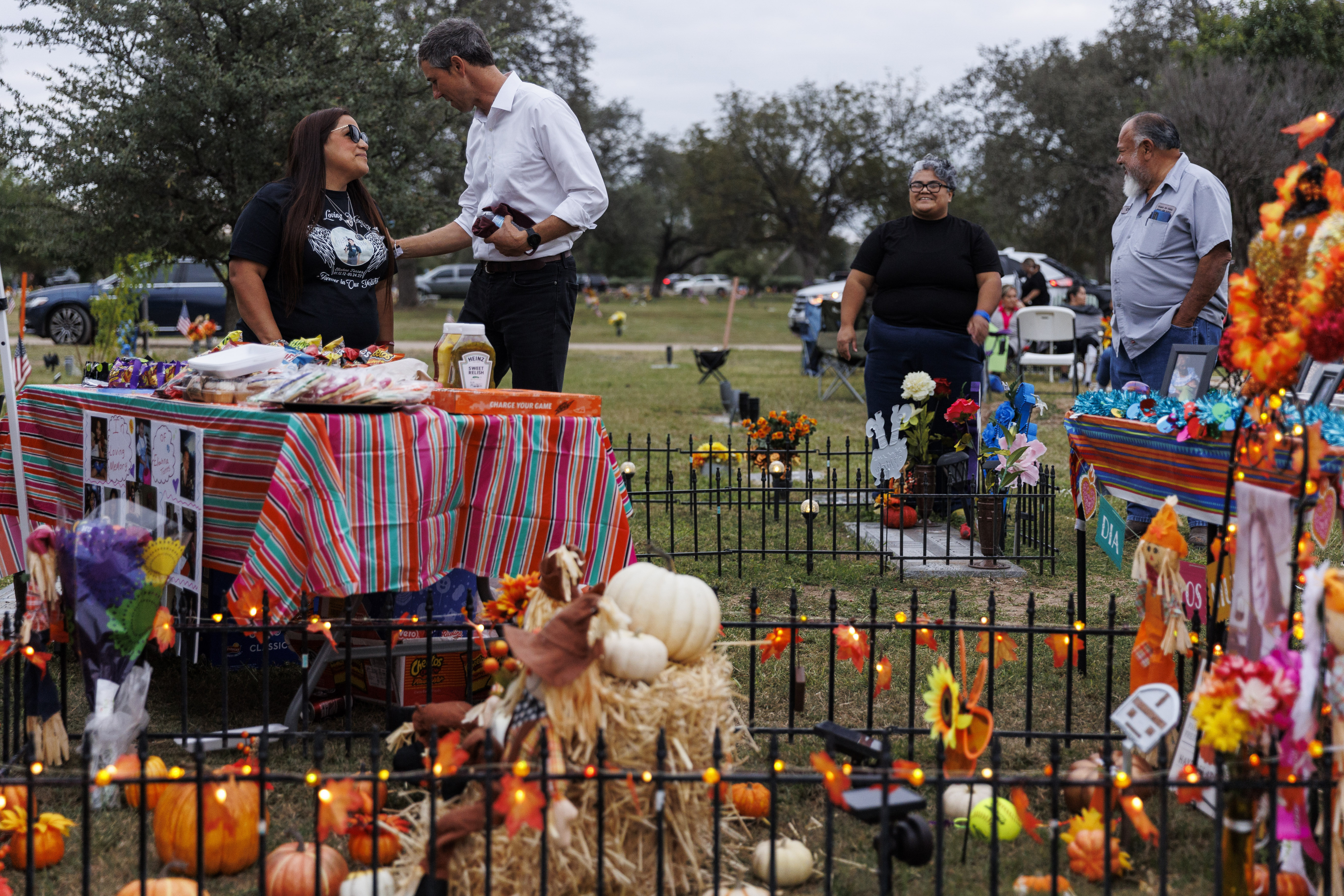 Sandra Cruz Torres, mother of Robb Elementary massacre victim Eliahna Torres, chats with Beto O'Rourke, Democratic candidate running for governor, as Cruz and her family celebrate Día de los Muertos at Torres' gravesite in Hillcrest Memorial Cemetery in Uvalde, Texas, Nov. 2. Torres filed a federal lawsuit on Monday against the police, the school district and the maker of the gun used in the massacre.
