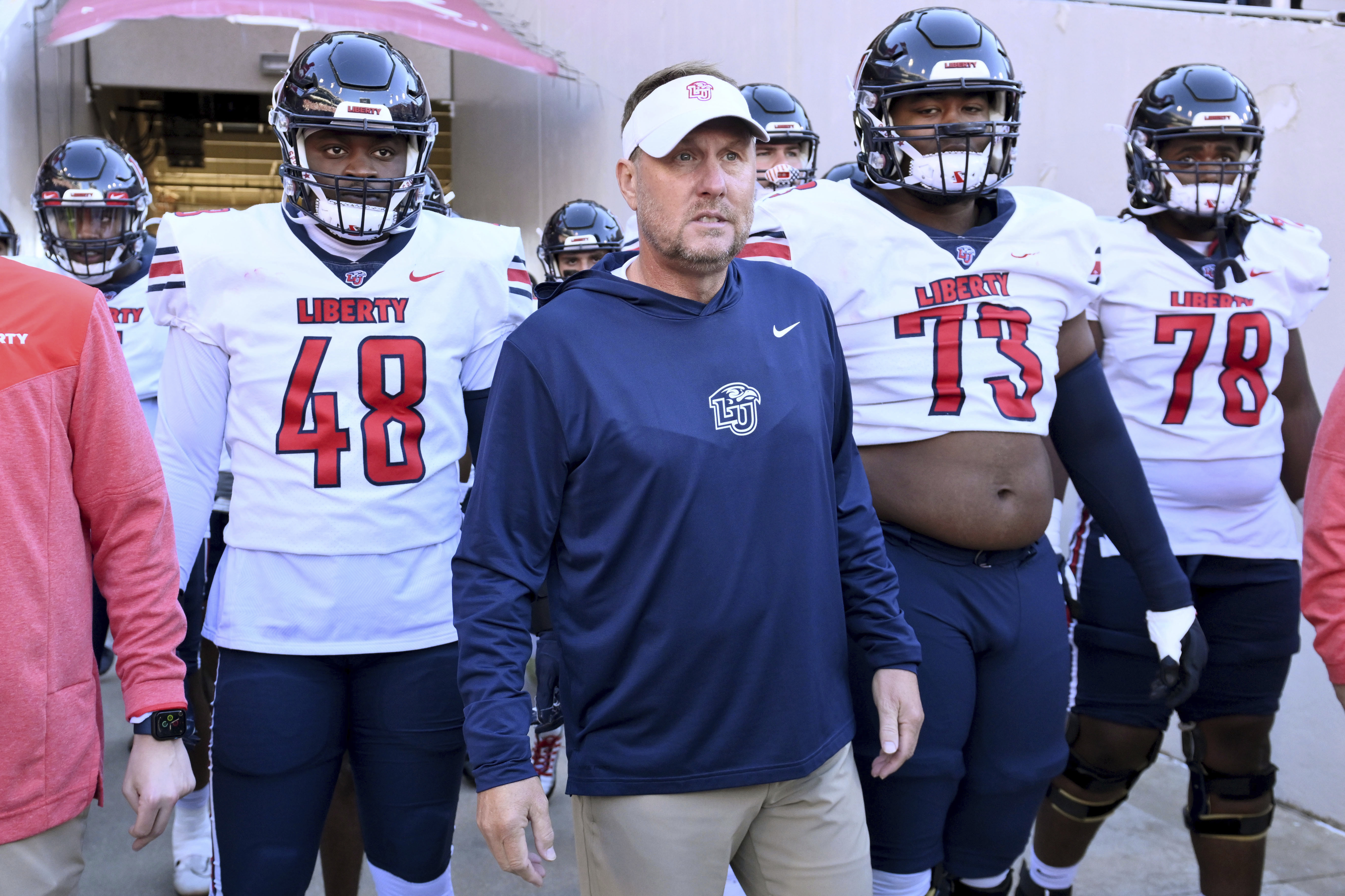 Liberty head coach Hugh Freeze, center, gets ready to take the field with his team to play Arkansas in an NCAA college football game Saturday, Nov. 5, 2022, in Fayetteville, Ark.