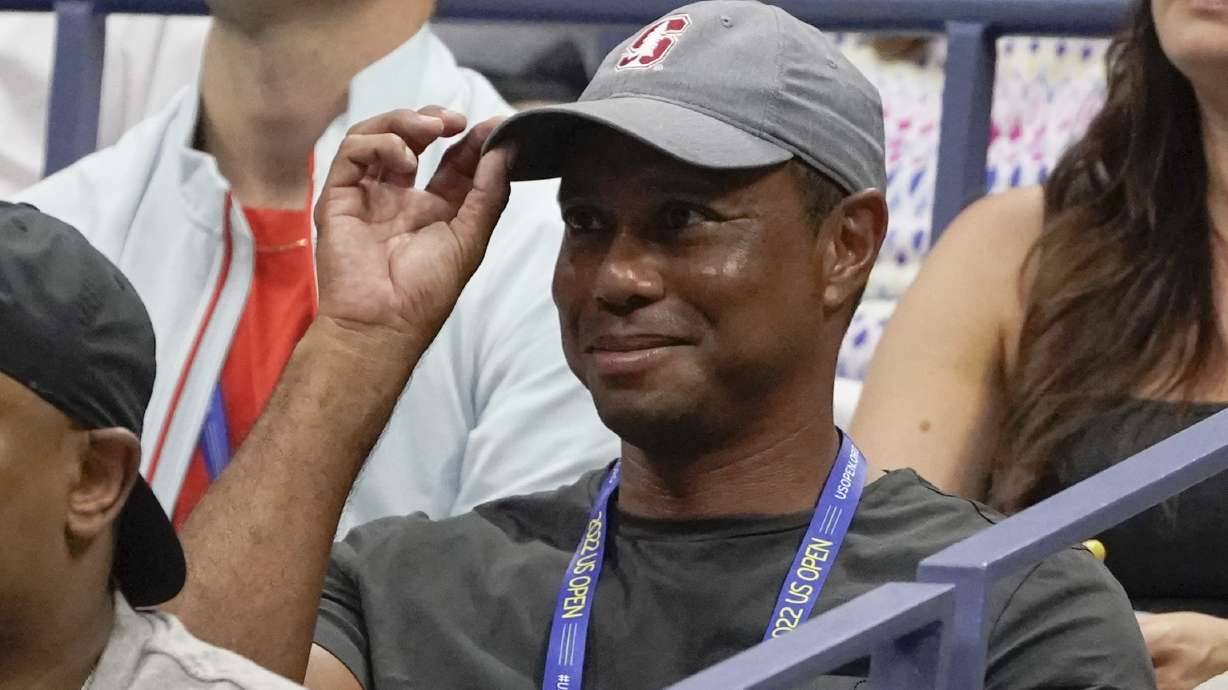 FILE - Tiger Woods tips his hat to the crowd during a match between Serena Williams and Anett Kontaveit, of Estonia, in the second round of the U.S. Open tennis championships, Wednesday, Aug. 31, 2022, in New York. Woods has won the Player Impact Program on the PGA Tour despite playing only three times. He is likely to play three unofficial events in December.