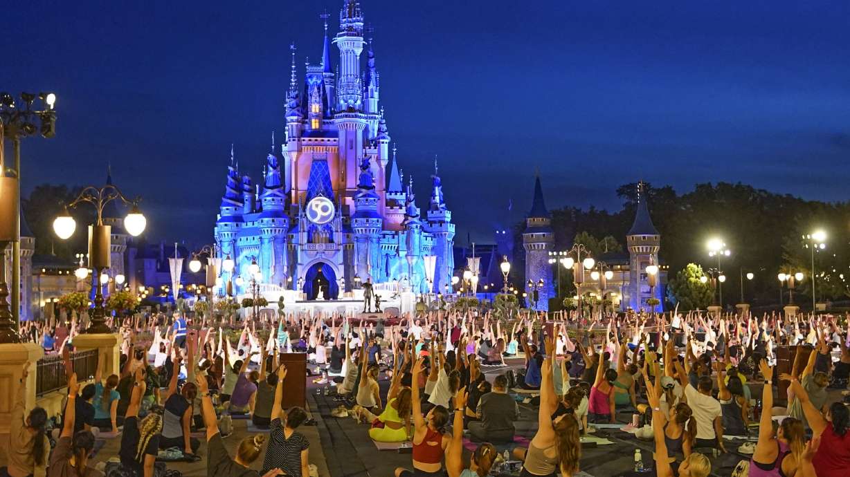 Nearly 2,000 cast members practice sunrise yoga celebrating International Yoga Day in front of Cinderella Castle at the Magic Kingdom Park at Walt Disney World on June 21, in Lake Buena Vista, Fla. While overall revenues were up, the profit margins fell well short of projections.
