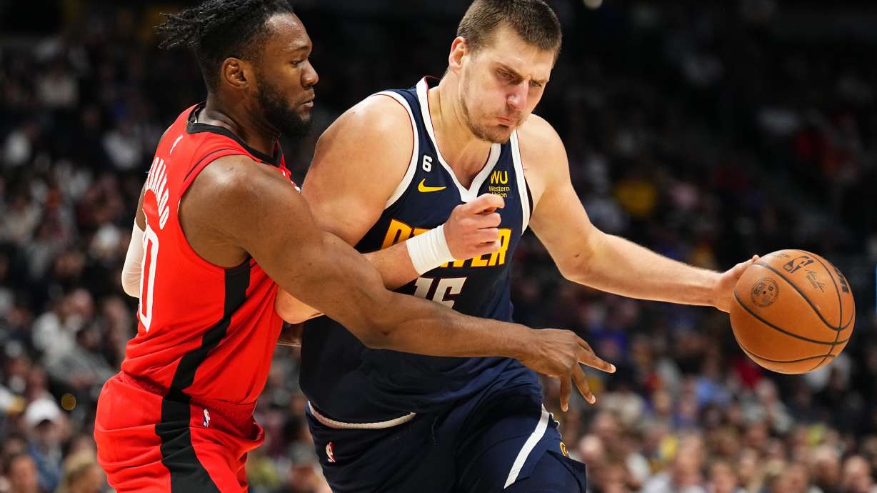 Denver Nuggets center Nikola Jokic, right, drives to the basket against Houston Rockets forward Bruno Fernando, left, during the third quarter of an NBA basketball game, Monday, Nov. 28, 2022, in Denver.