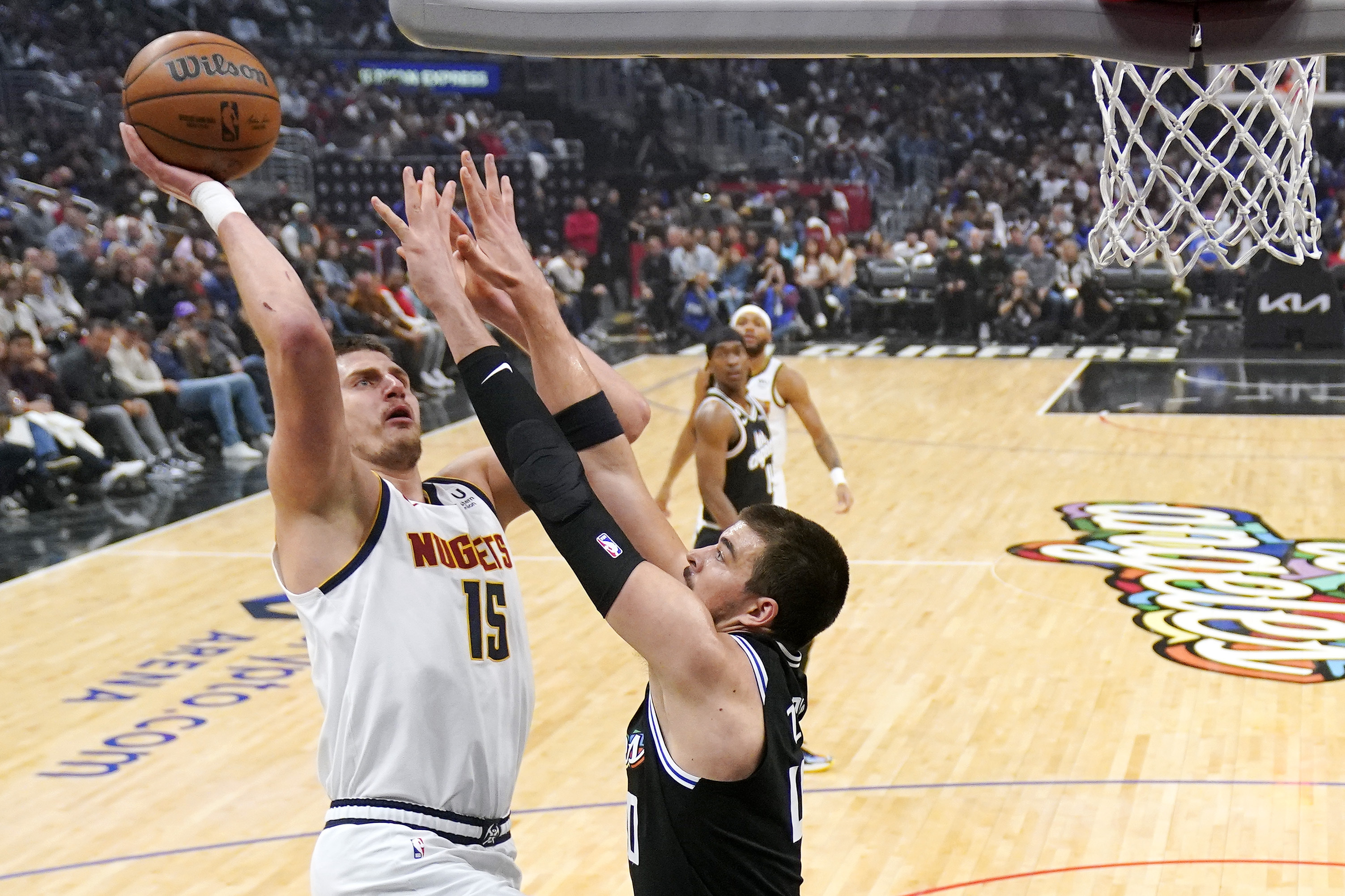 Denver Nuggets center Nikola Jokic, left, shoots as Los Angeles Clippers center Ivica Zubac defends during the first half of an NBA basketball game Friday, Nov. 25, 2022, in Los Angeles. 