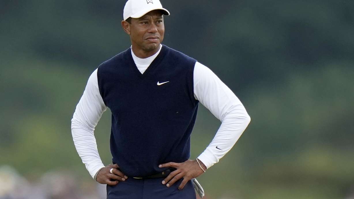 FILE - Tiger Woods, of the United States, stands on the 11th hole during the first round of the British Open golf championship on the Old Course at St. Andrews, Scotland, on July 14, 2022. Woods was out before he was officially back, withdrawing Monday, Nov. 28, 2022, from his Hero World Challenge with plantar fasciitis in his right foot.
