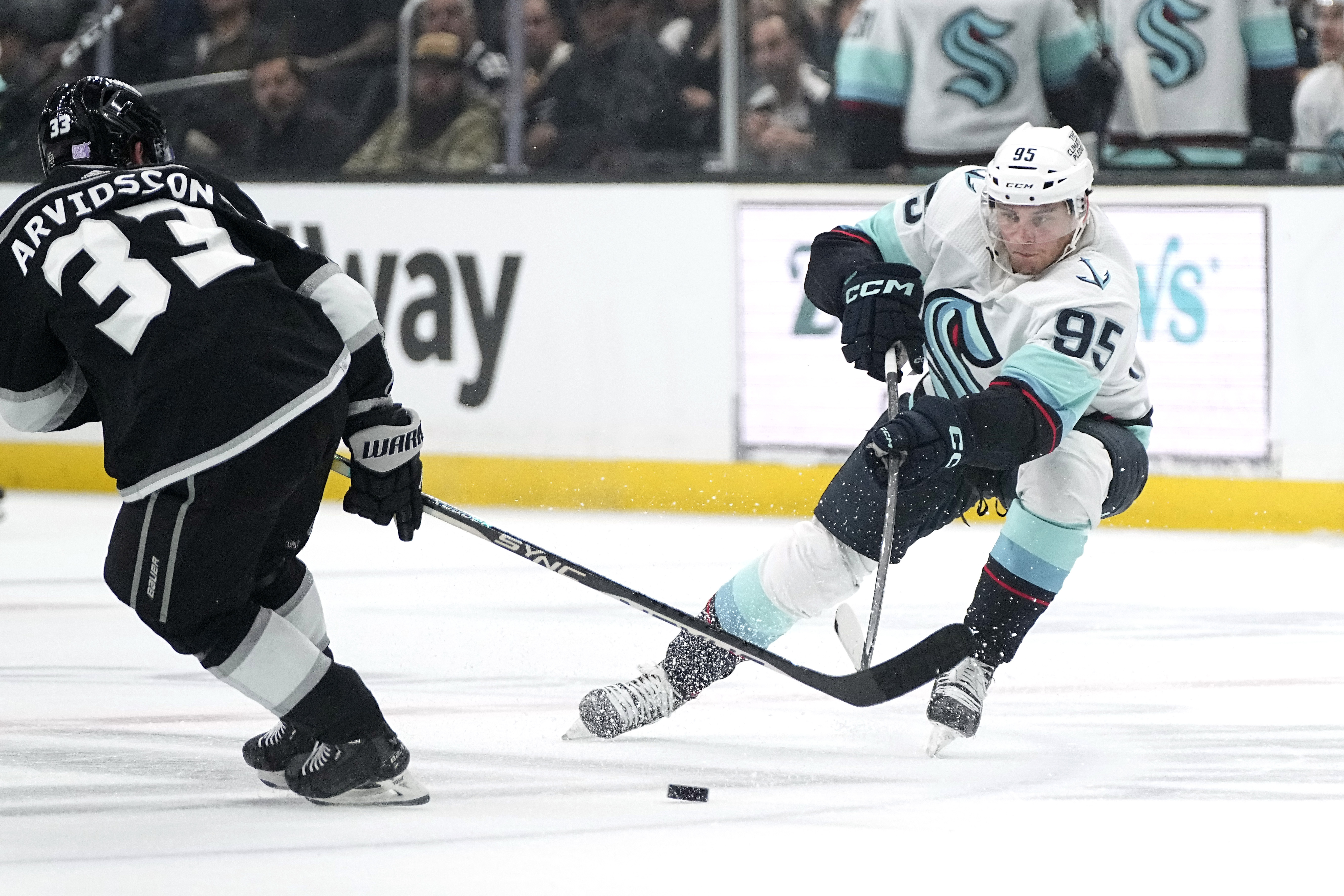 Seattle Kraken left wing Andre Burakovsky, right, passes the puck past Los Angeles Kings right wing Viktor Arvidsson during the first period of an NHL hockey game Tuesday, Nov. 29, 2022, in Los Angeles. 