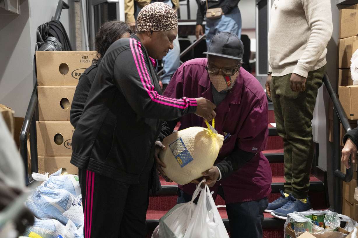 Ricardo Barrett, of Washington, accepts a turkey from church volunteer Rita James, left, during an annual Thanksgiving food giveaway at The Redeemed Christian Church of God New Wine Assembly, Nov. 22, in Washington. "Prices went up and a lot of jobs were lost this year," says Barrett, "times are hard."