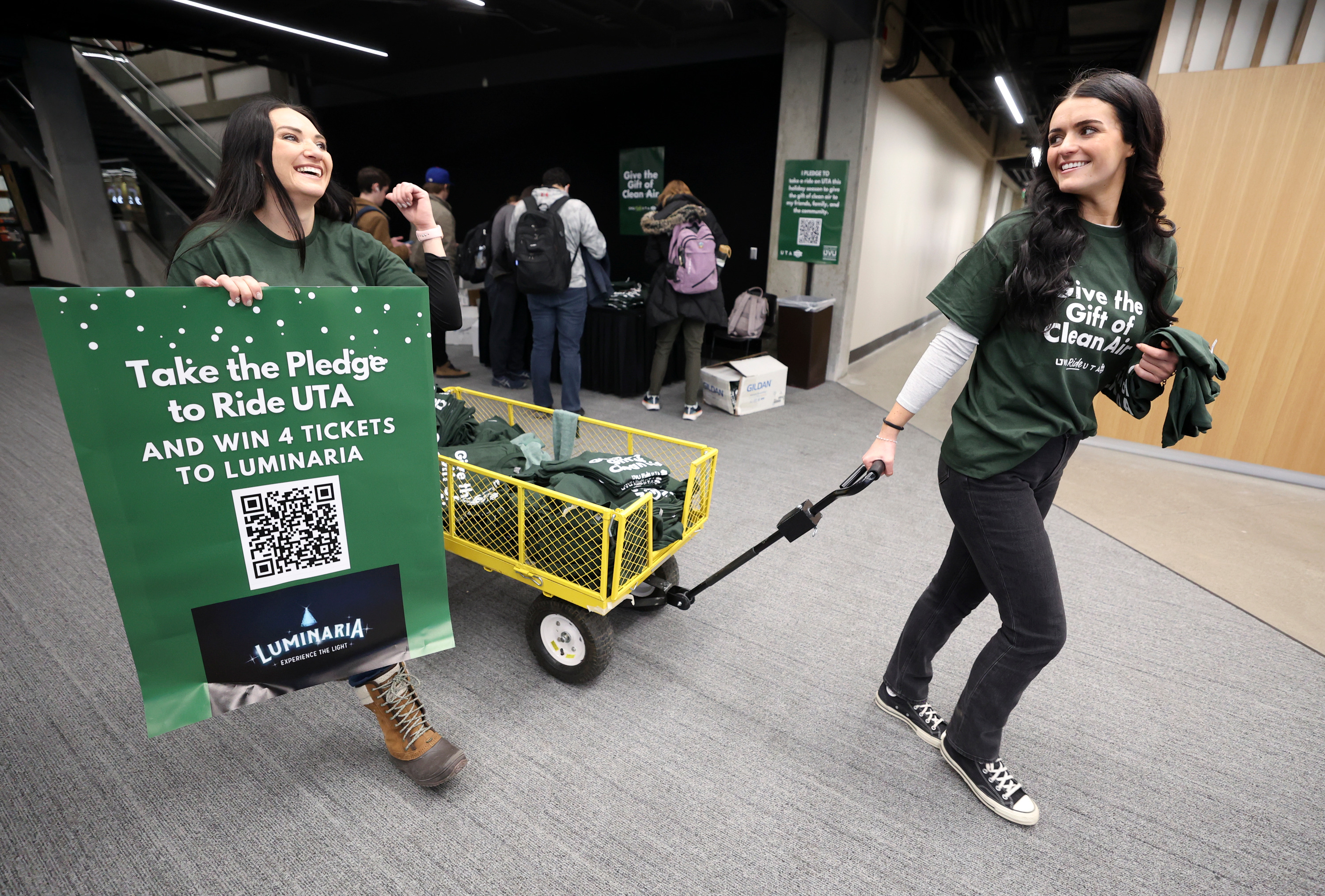 Utah Valley University Sustainability Clean Air Campaign project leaders Emery Williams, left, and Kiersten Thomson hand out T-shirts and ask students and faculty to pledge to ride public transportation, which is free for all students, staff and their dependents, in Orem on Wednesday.