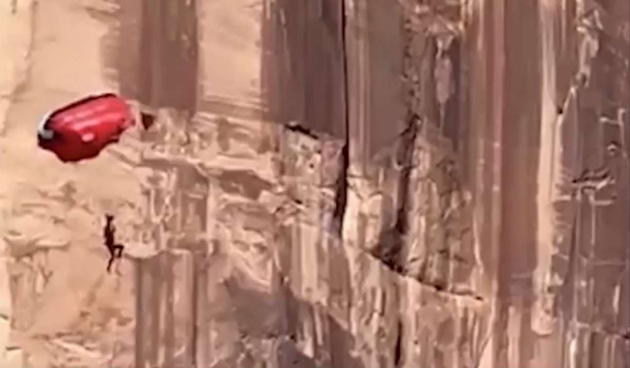 Incredible video shows the terrifying moments a BASE jumper crashed into a cliff in Moab on Saturday, then hung in the air high above the ground, his parachute stuck in the cliffside.