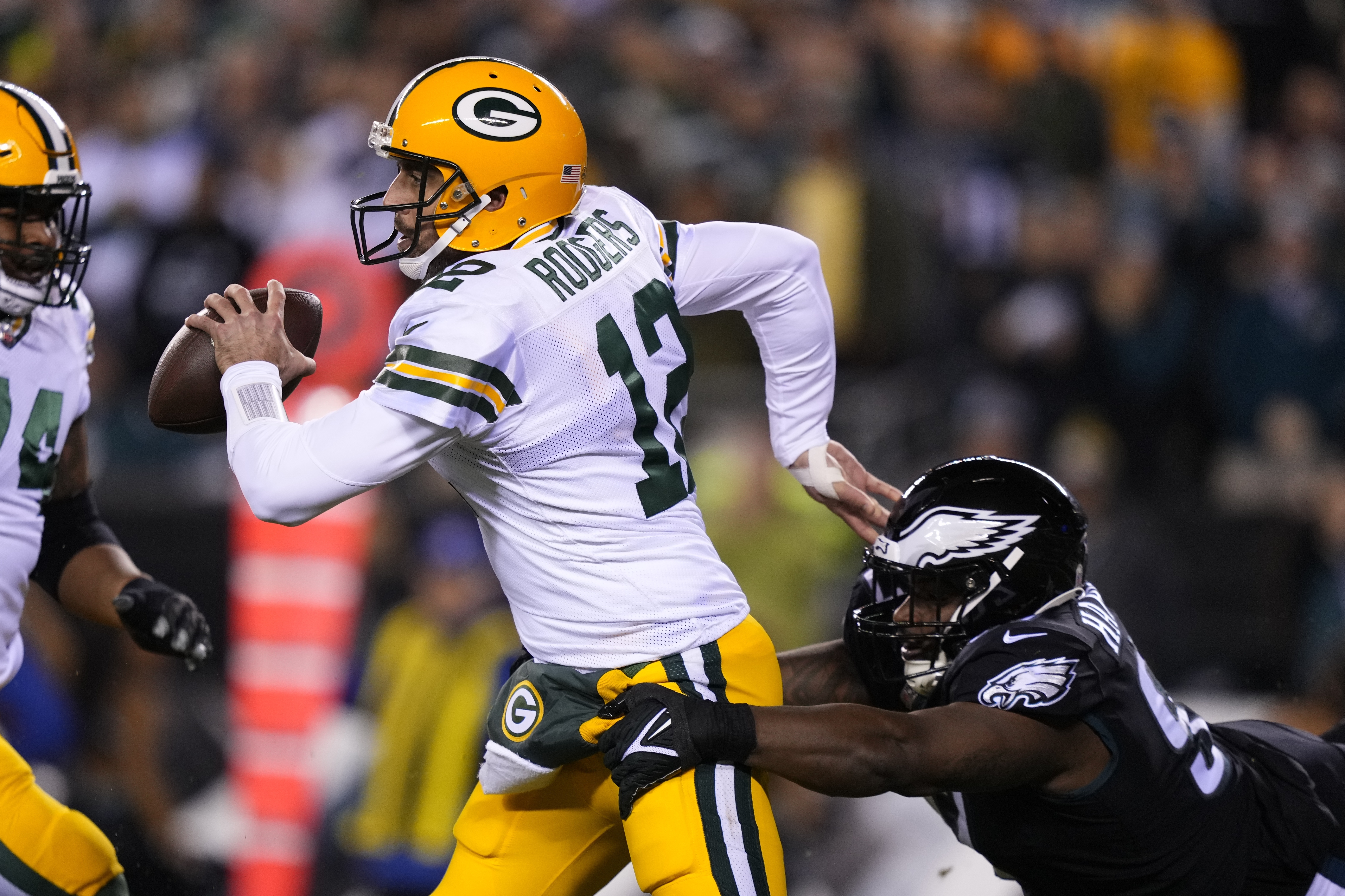Green Bay Packers quarterback Aaron Rodgers (12) is pressured by Philadelphia Eagles' Javon Hargave during the first half of an NFL football game, Sunday, Nov. 27, 2022, in Philadelphia.