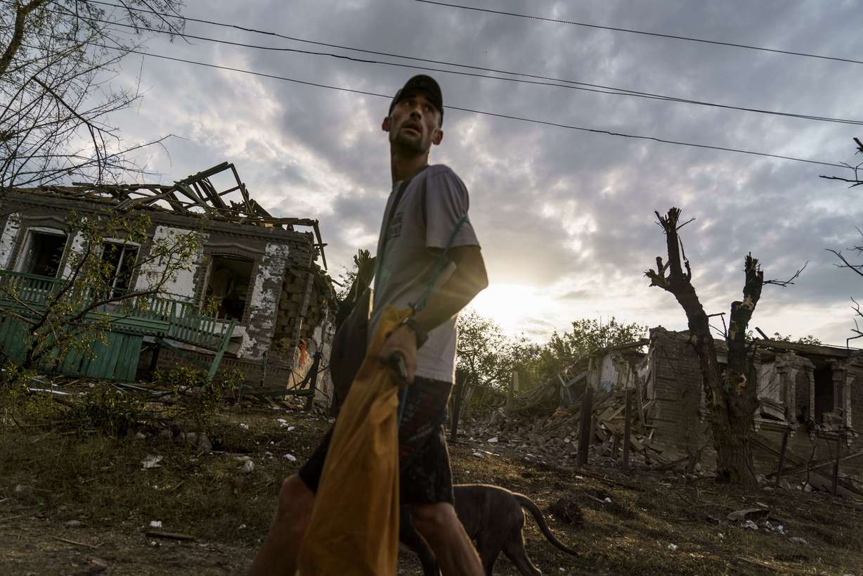 A person walks past homes damaged in a rocket attack earlier in the morning on Aug. 16, in Kramatorsk, eastern Ukraine, as Russian shelling continued to hit towns and villages in Donetsk province.