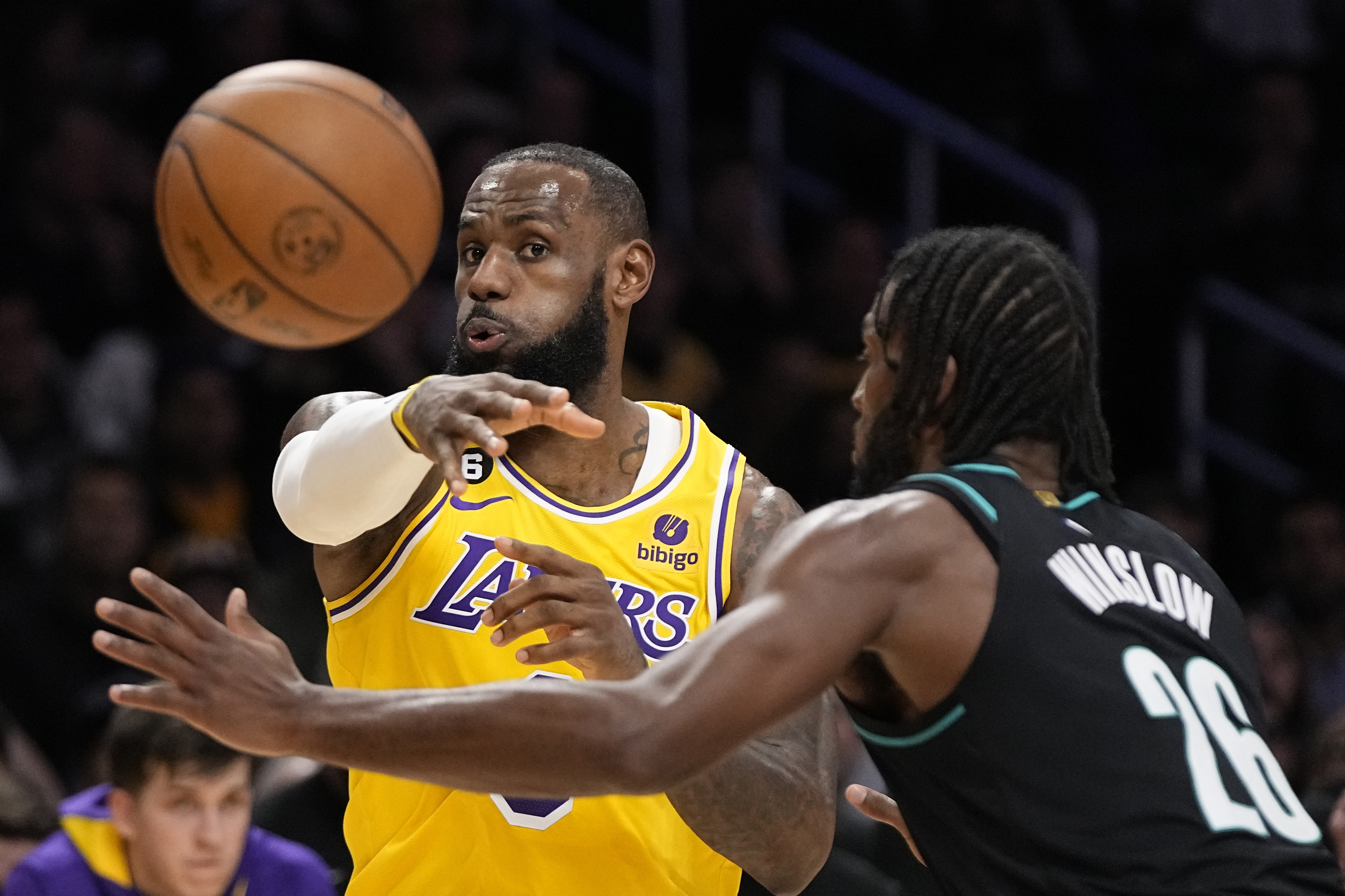 Los Angeles Lakers forward LeBron James, left, passes the ball as Portland Trail Blazers forward Justise Winslow defends during the first half of an NBA basketball game Wednesday, Nov. 30, 2022, in Los Angeles. 