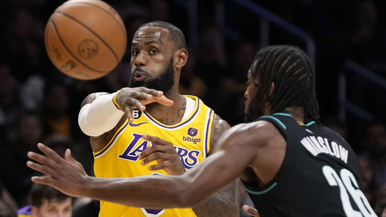 Los Angeles Lakers forward LeBron James, left, passes the ball as Portland Trail Blazers forward Justise Winslow defends during the first half of an NBA basketball game Wednesday, Nov. 30, 2022, in Los Angeles.