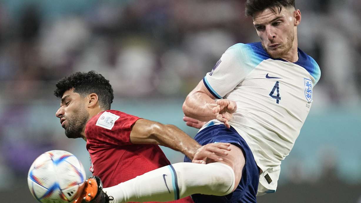 England's Declan Rice, right, kicks the ball past Iran's Mehdi Taremi during the World Cup group B soccer match between England and Iran at the Khalifa International Stadium in Doha, Qatar, Monday, Nov. 21, 2022.