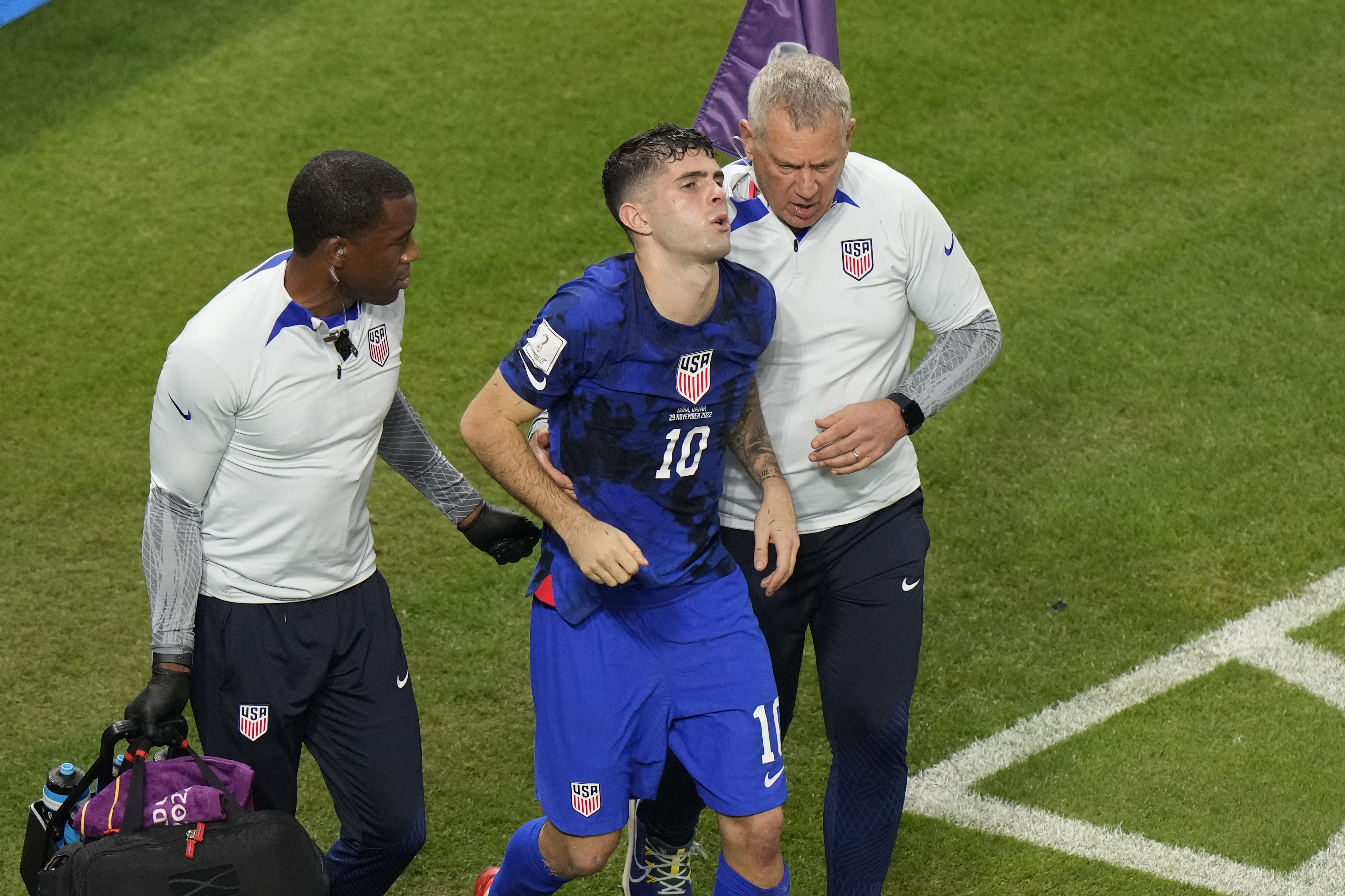Christian Pulisic of the United States is helped by team doctors after he scoring his side's opening goal during the World Cup group B soccer match between Iran and the United States at the Al Thumama Stadium in Doha, Qatar, Tuesday, Nov. 29, 2022. 