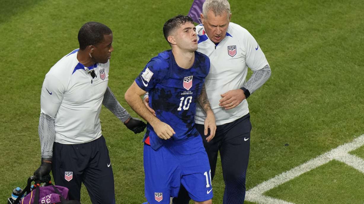 Christian Pulisic of the United States is helped by team doctors after he scoring his side's opening goal during the World Cup group B soccer match between Iran and the United States at the Al Thumama Stadium in Doha, Qatar, Tuesday, Nov. 29, 2022.